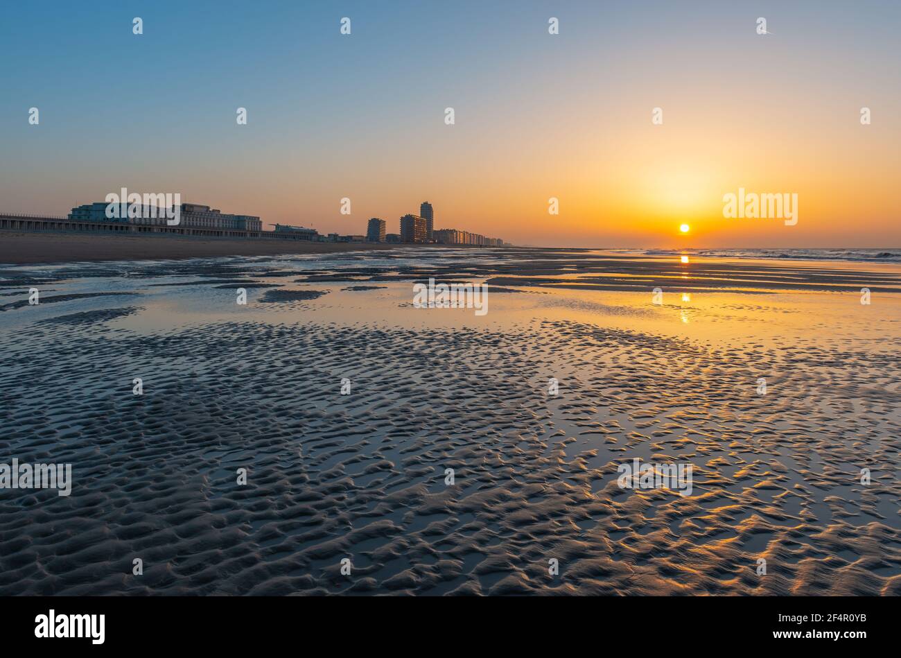 Oostende (Ostende) plage au bord de la mer du Nord au coucher du soleil avec des ondulations de sable, Flandre Occidentale, Belgique. Banque D'Images
