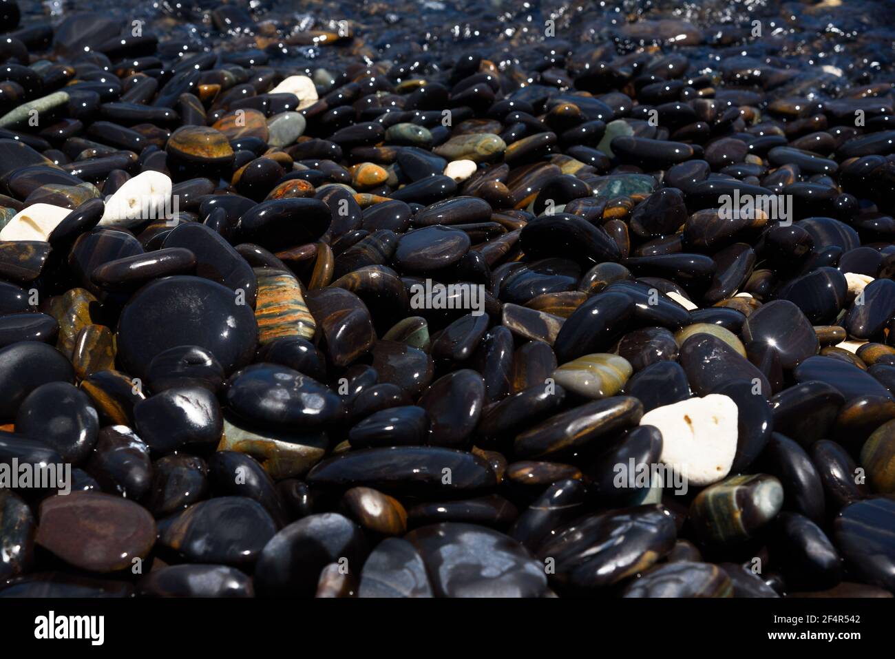 Vue rapprochée de pierres noires lisses à koh hin ngam, province de Satun, Thaïlande. Banque D'Images