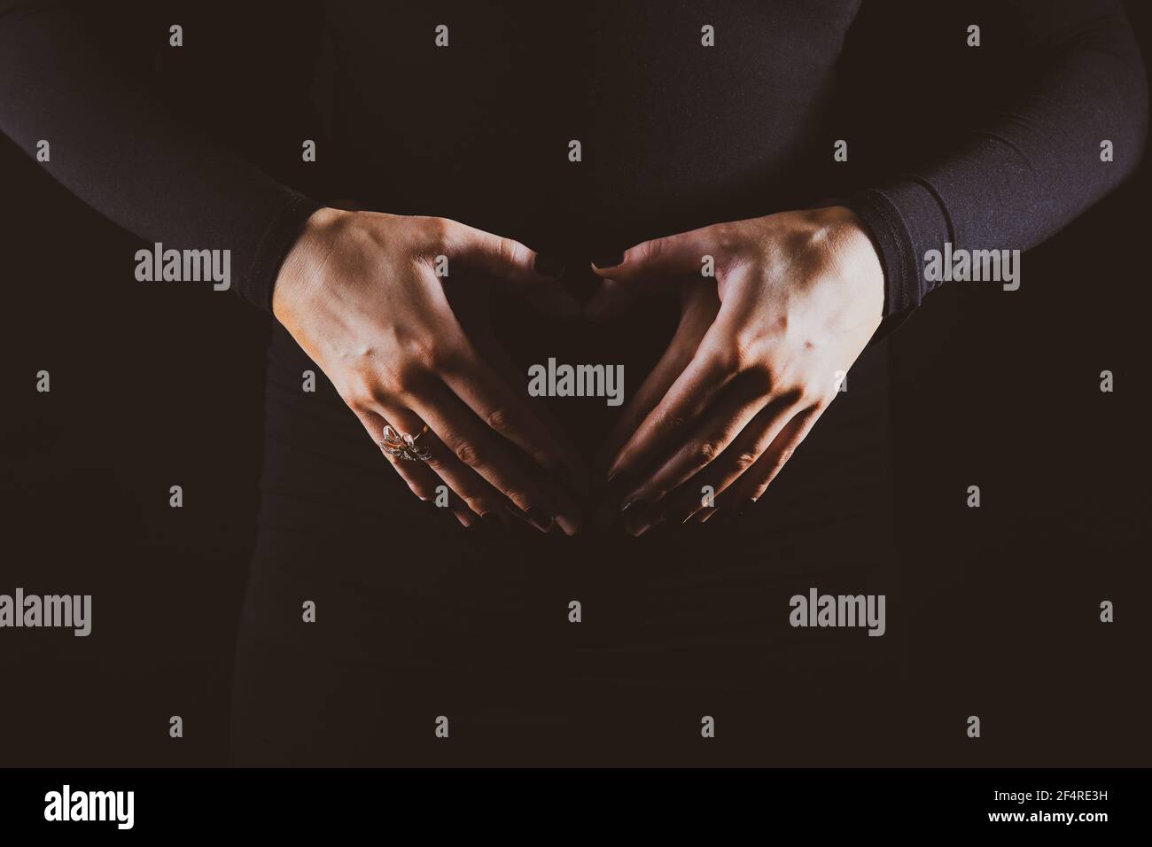 Une mère enceinte tenant son ventre en forme de un cœur Banque D'Images