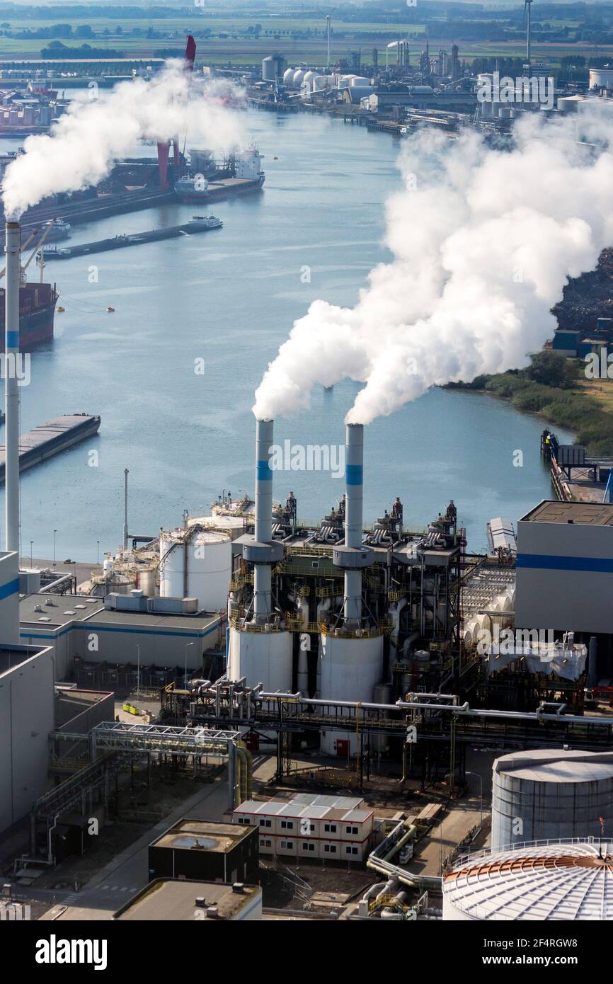 Pollution de l'air due à l'évacuation des cheminées dans une usine de traitement des déchets dans un grand port industriel. Banque D'Images