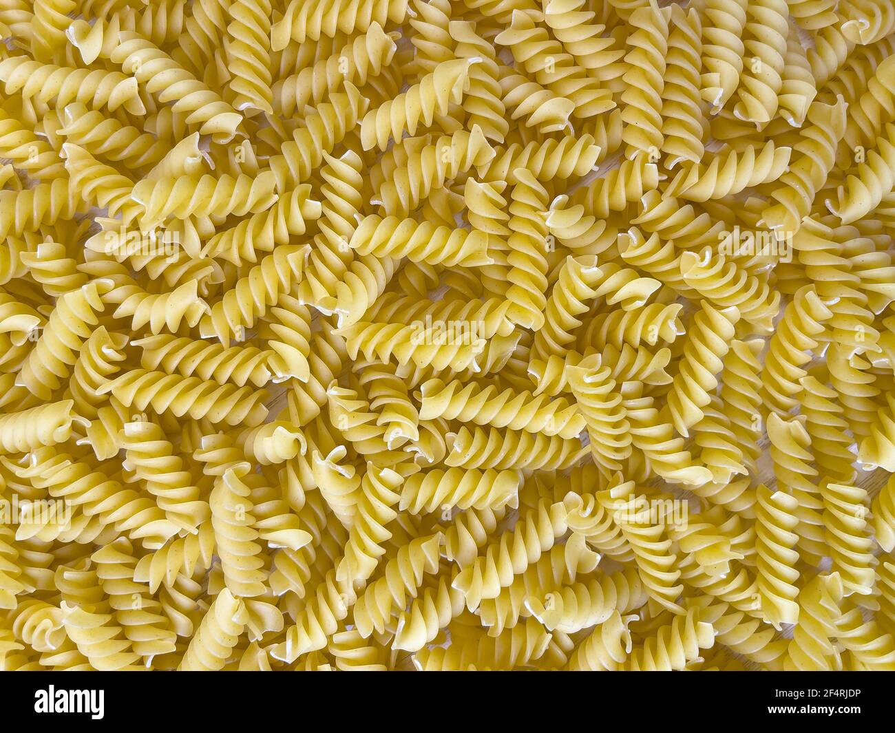 Fond ou texture de la nourriture pâtes italiennes sèches crues en forme de spirale. Gros plan, macro, vue de dessus. Macaroni non cuit Banque D'Images