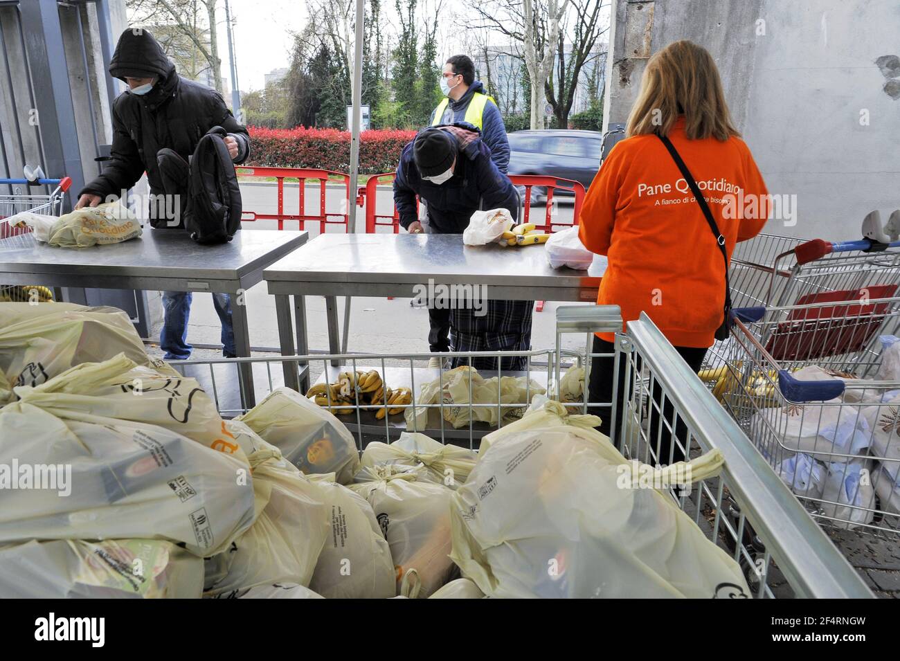 Milan (Italie), le volet organisme à but non lucratif Quotidiano (Daily Bread) distribue des denrées alimentaires essentielles aux personnes en difficulté économique en raison de la crise causée par l'épidémie du coronavirus. De plus en plus de groupes sociaux sont touchés, et chaque jour la file d'attente devient plus longue. Banque D'Images