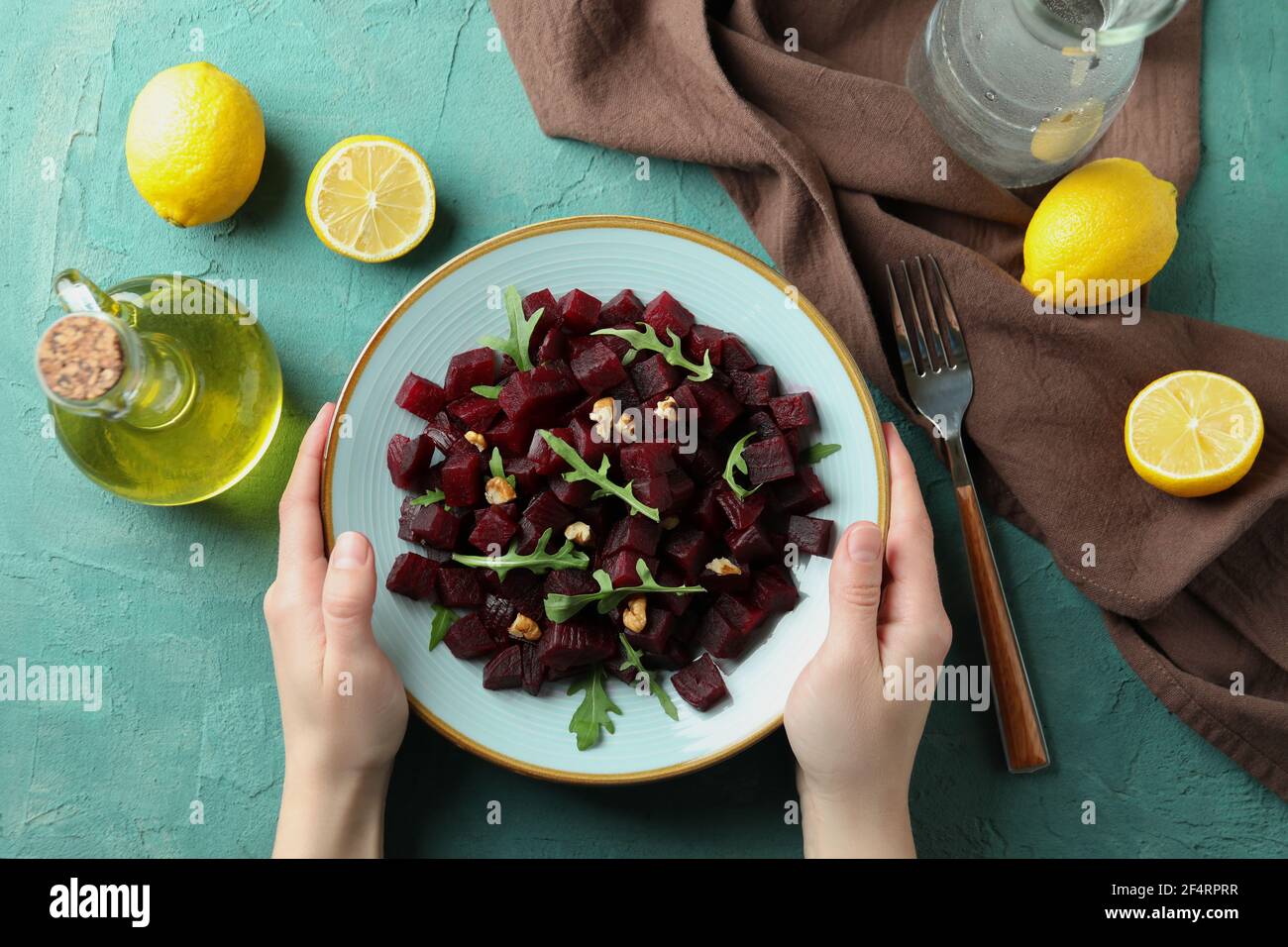 Assiette de salade de betteraves savoureuses pour les mains des femmes, vue du dessus Banque D'Images