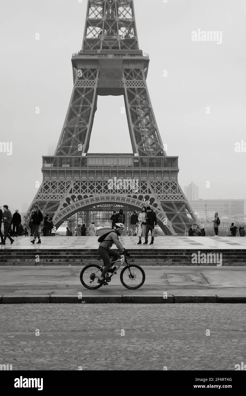 Paris, France - janvier 31 2021 : Cycliste devant la tour Eiffel par une journée nuageux Banque D'Images