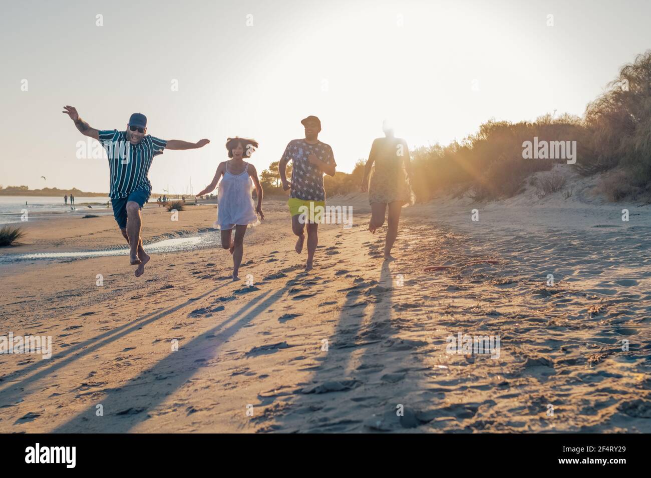 jeunes amis jouant et s'amusant en courant et sautant sur la plage en vacances. activité estivale. amitié, amusement et unité concept Banque D'Images