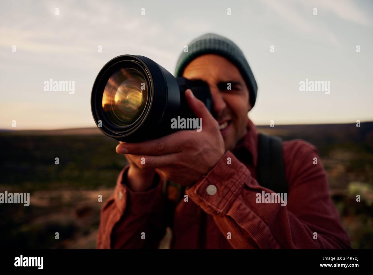 Jeune randonneur prenant des photos de montagnes et beau lever de soleil avec appareil photo professionnel Banque D'Images