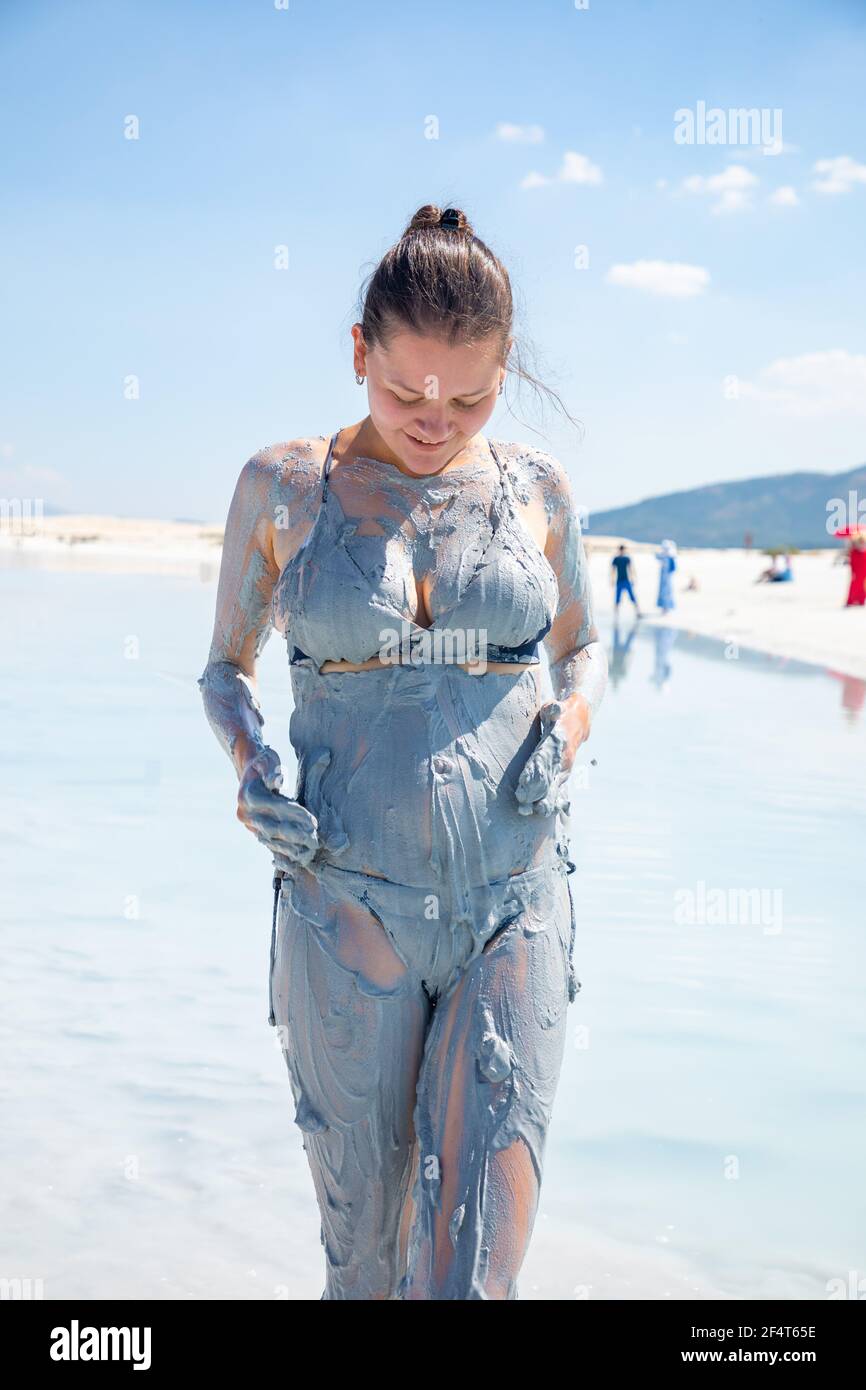 Happy et drôle touriste femelle prend des taches d'argile cosmétique naturelle à son corps sur le lac Salda, Turquie Banque D'Images