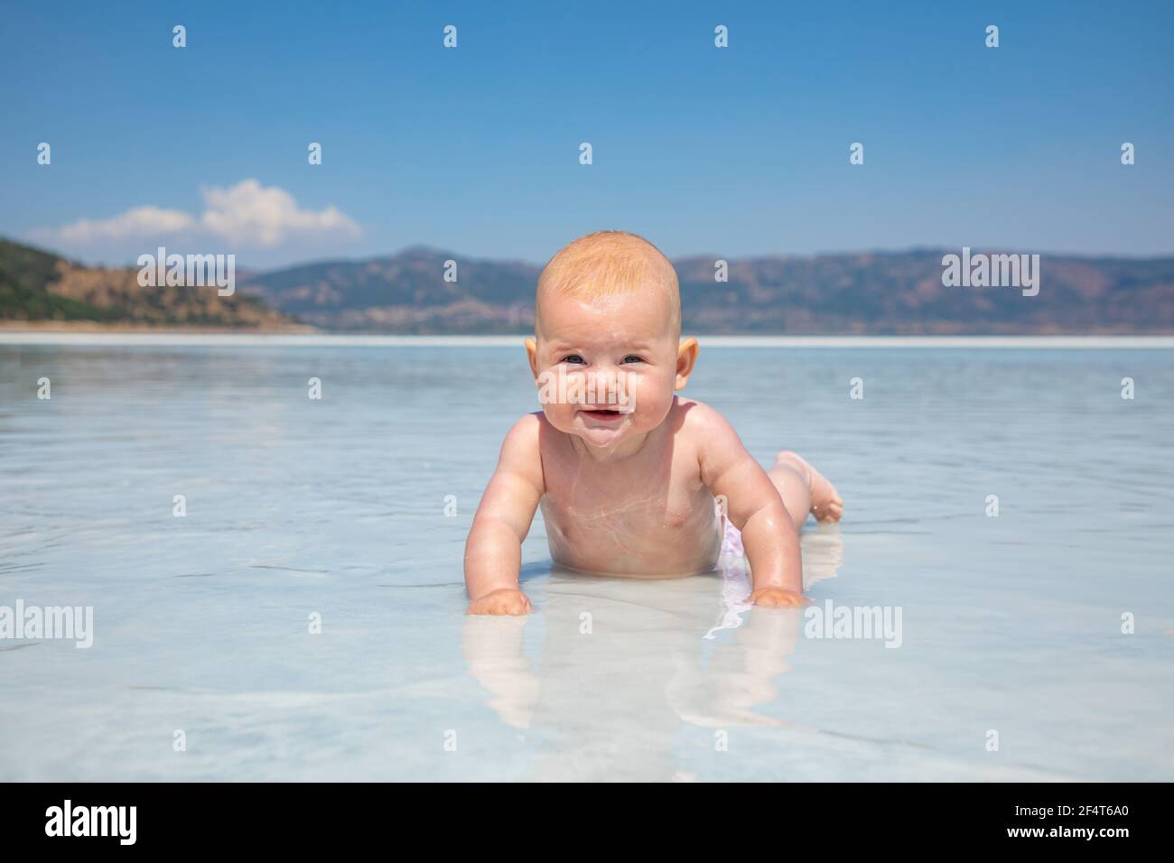 Bebe Fille En Costume De Bain Rose Est Pose Sur L Argile Blanche De Cratere Turquoise Lac Salda Golu Turquie Photo Stock Alamy