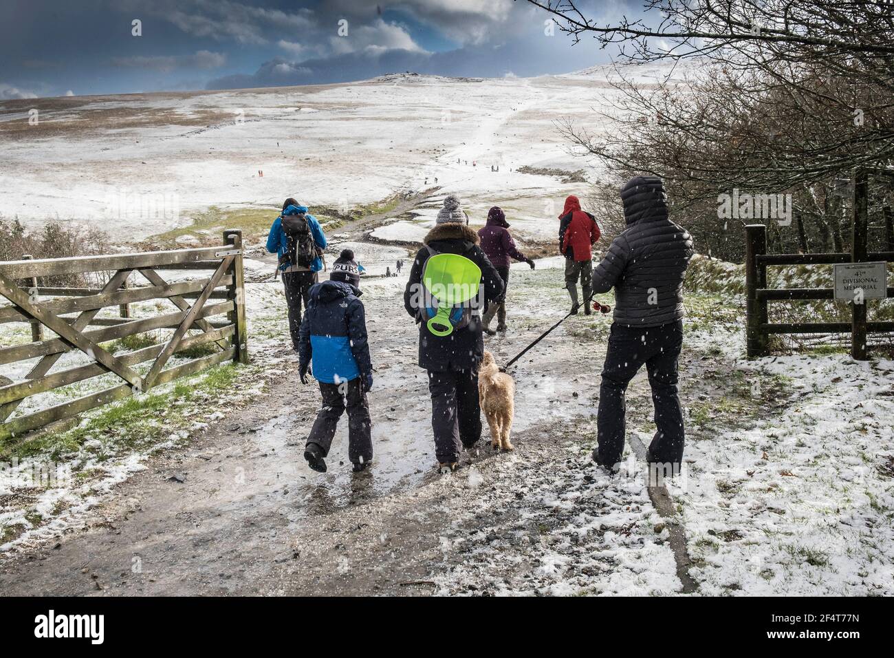 Une famille qui s'amusent à marcher dans la neige sur la sauvage sauvage Rough Tor sur Bodmin Moor dans les Cornouailles. Banque D'Images