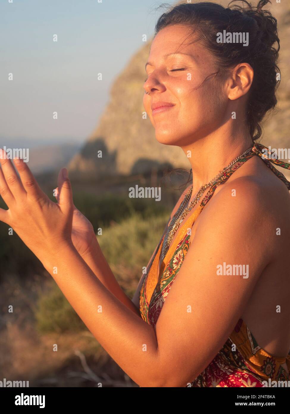 Femme confiante dansant avec un sourire au coucher du soleil. Banque D'Images