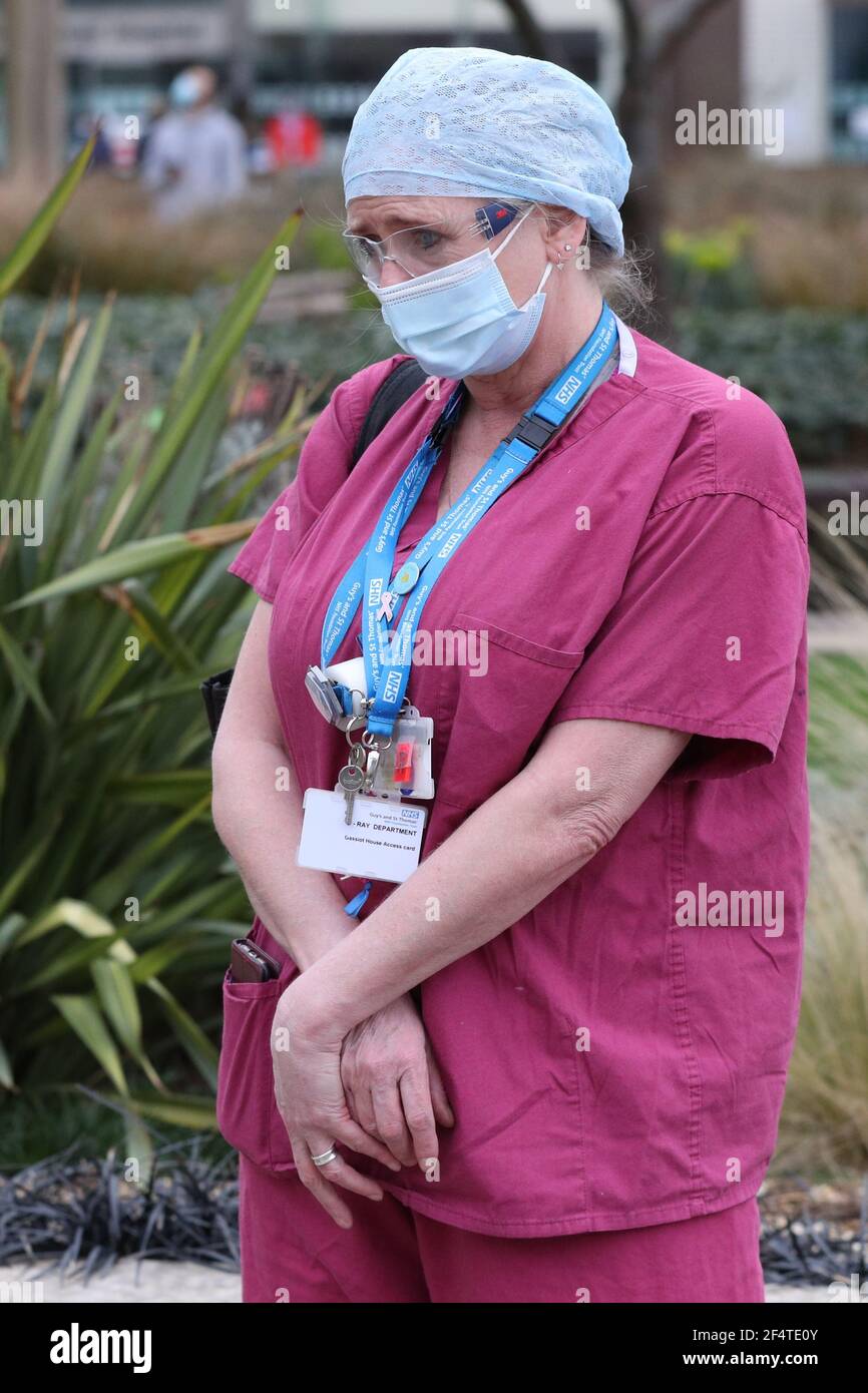 Un membre du personnel se tient lors d'une cérémonie à l'hôpital St Thomas, dans le centre de Londres, dans le cadre de la Journée nationale de réflexion sur l'anniversaire du premier confinement national visant à prévenir la propagation du coronavirus. Date de la photo: Mardi 23 mars 2021. Banque D'Images