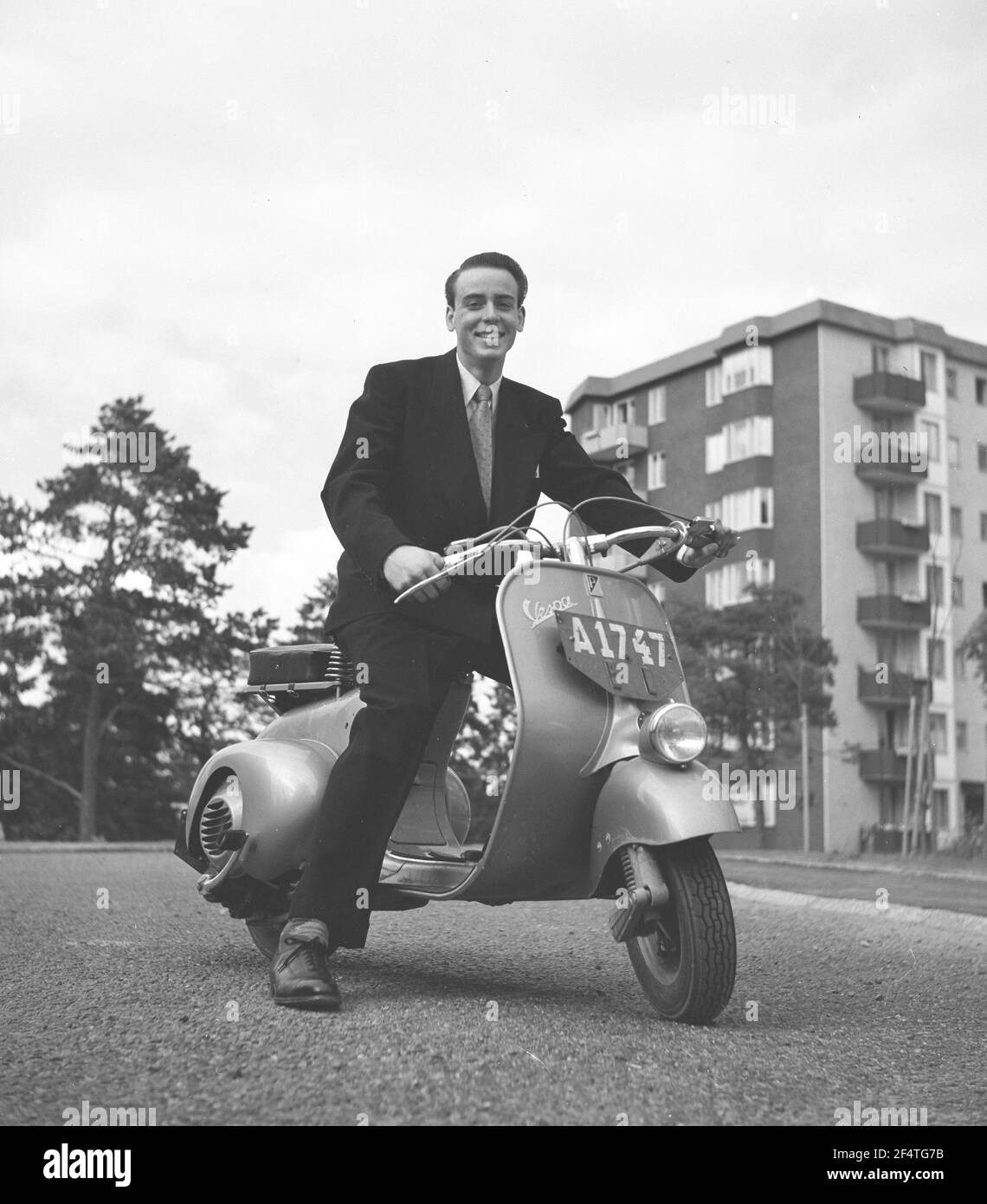 Vespa. Une marque italienne de scooter fabriqué par Piaggio. Le 23 avril 1946, Piaggio & C. S.p.A. a déposé un brevet pour "un cycle moteur avec un complexe rationnel d'organes et d'éléments avec corps combiné avec les garde-boue et le capot couvrant toutes les pièces mécaniques". Peu de temps après, la Vespa a fait sa première apparition publique. Il est Henry Hasso, fils de l'actrice signe Hasso en juillet 1952. Banque D'Images