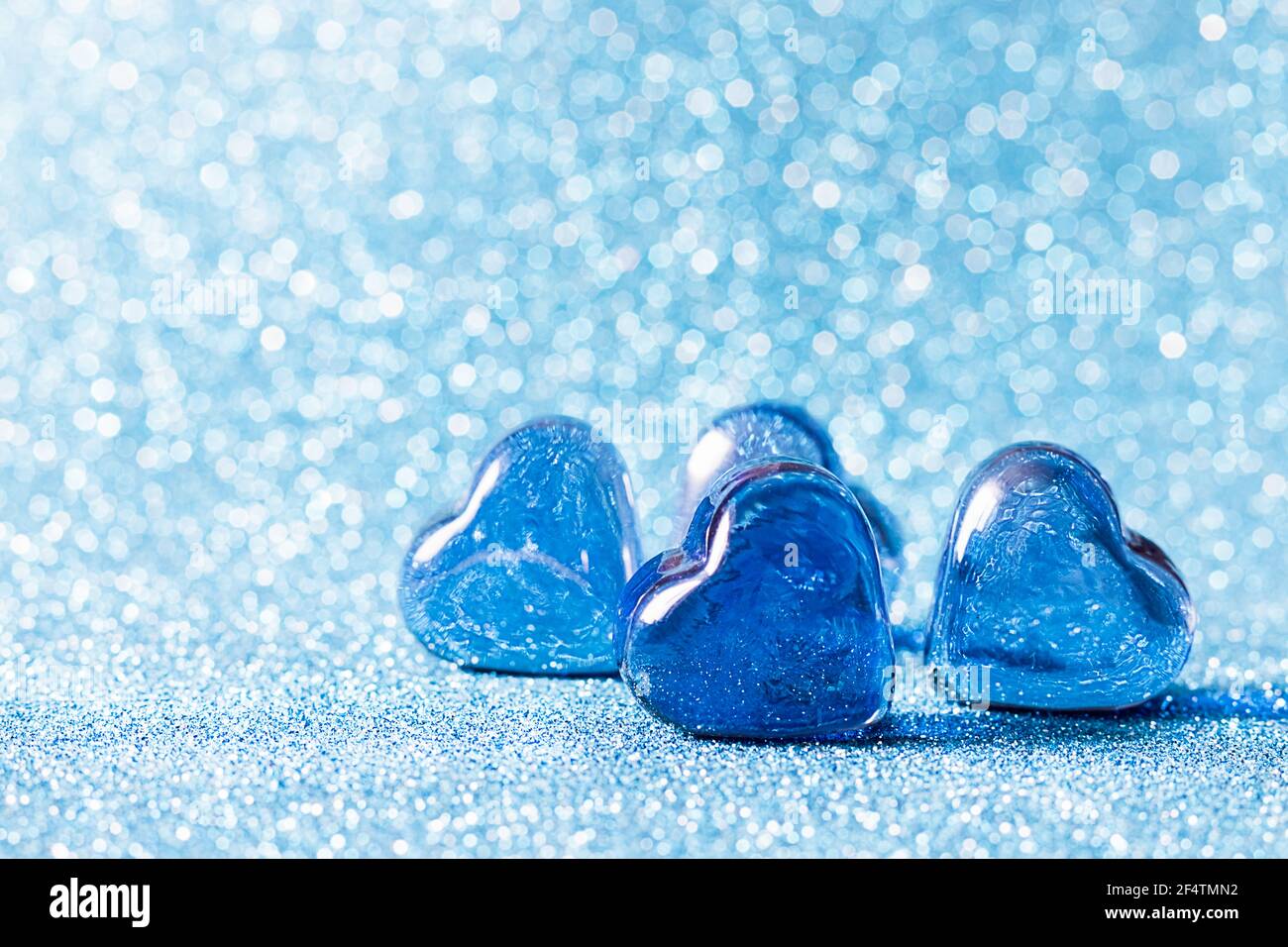 Coeurs bleus de verre sur fond bleu. Concepts de carte de jour de Saint Valentin, mariage et invitation. Place pour votre texte. Banque D'Images