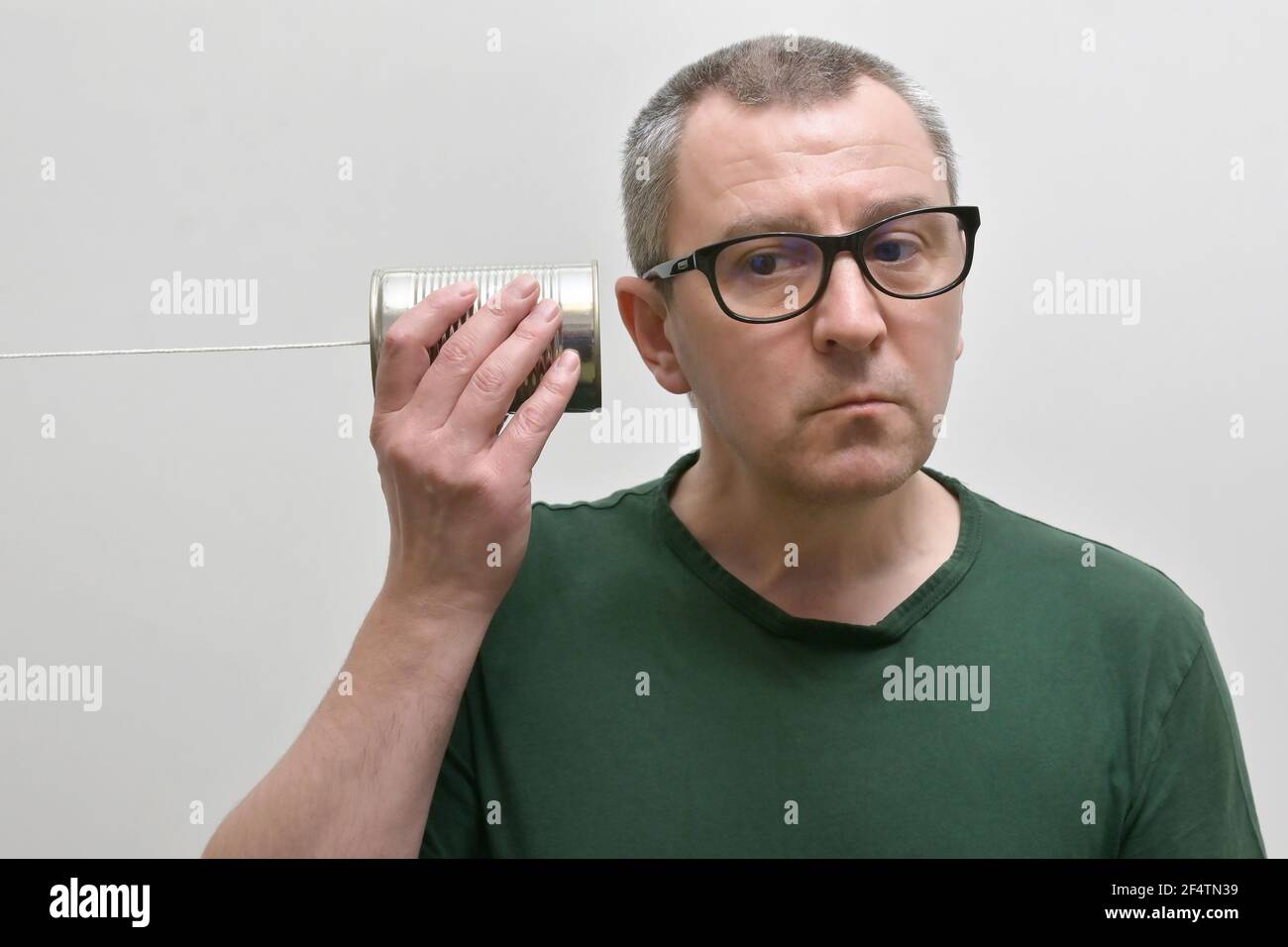 Portrait d'UN homme utilisant et écoutant UNE boîte de étain Téléphone Banque D'Images