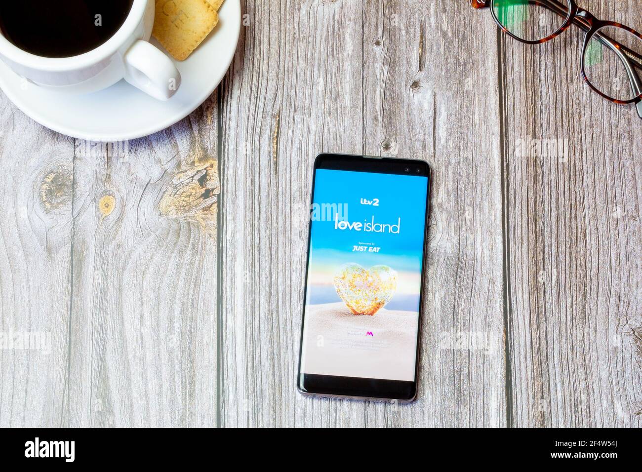 Un téléphone portable ou mobile posé sur un bois Table avec l'application Love Island ouverte à l'écran Banque D'Images