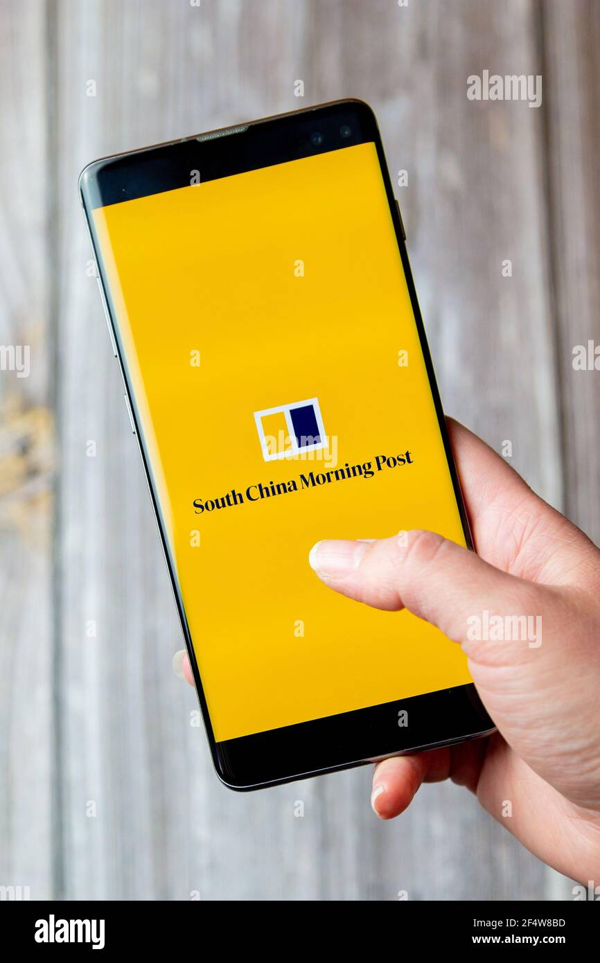 Un téléphone mobile ou mobile tenu dans un Main avec l'application de post du matin de Chine du Sud ouverte le écran Banque D'Images