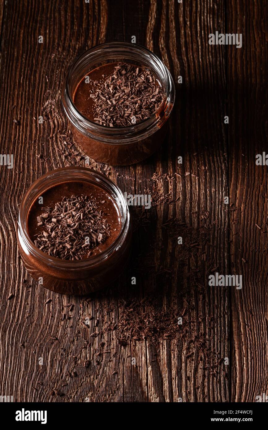 Mousse au chocolat noir maison dans des pots ruraux sur du bois rustique arrière-plan Banque D'Images