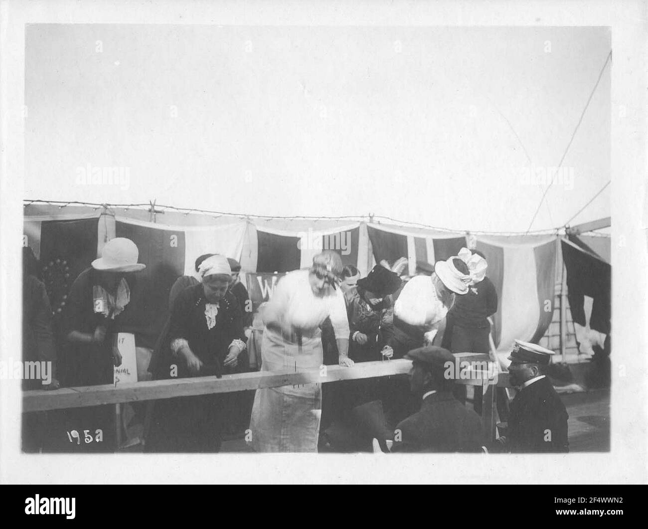 Croisières de la ligne Hambourg-Amérique, photos à bord. Touristes pendant une compétition dans un nailfold dans un festival corsé sur le pont d'un paquebot de haute mer (Guess Cleveland), en arrière-plan bannières de différentes nations sur le rail Banque D'Images