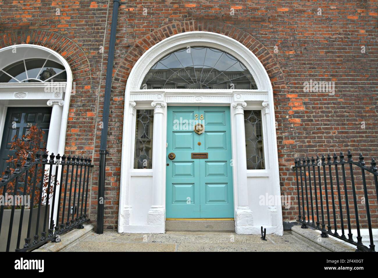 Façade en briques anciennes de style géorgien avec porte d'entrée voûtée turquoise sur Merrion Square Dublin, Irlande. Banque D'Images