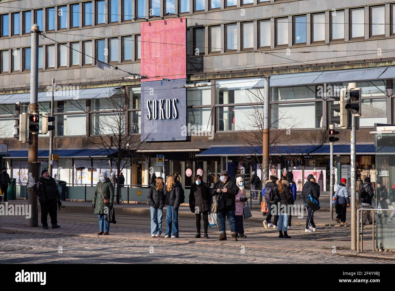 Personnes debout aux feux de signalisation par Mannerheimintie, le grand magasin Sokos en arrière-plan, à Helsinki, en Finlande. Banque D'Images