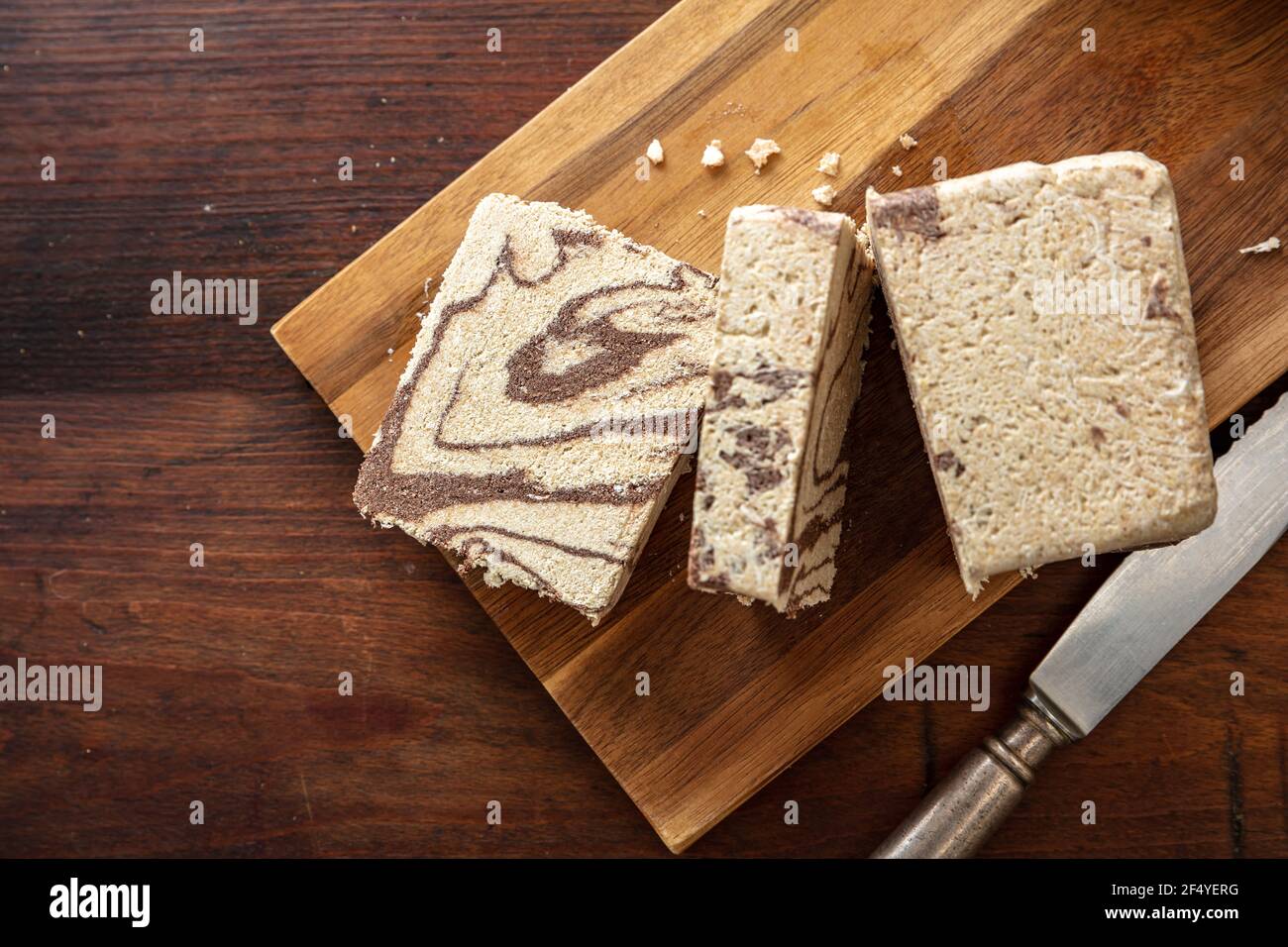 Morceaux de graines de cacao et de tournesol de halva sur fond de table en bois, vue du dessus. Halah ou halwa au chocolat, dessert traditionnel avec la décoration Banque D'Images