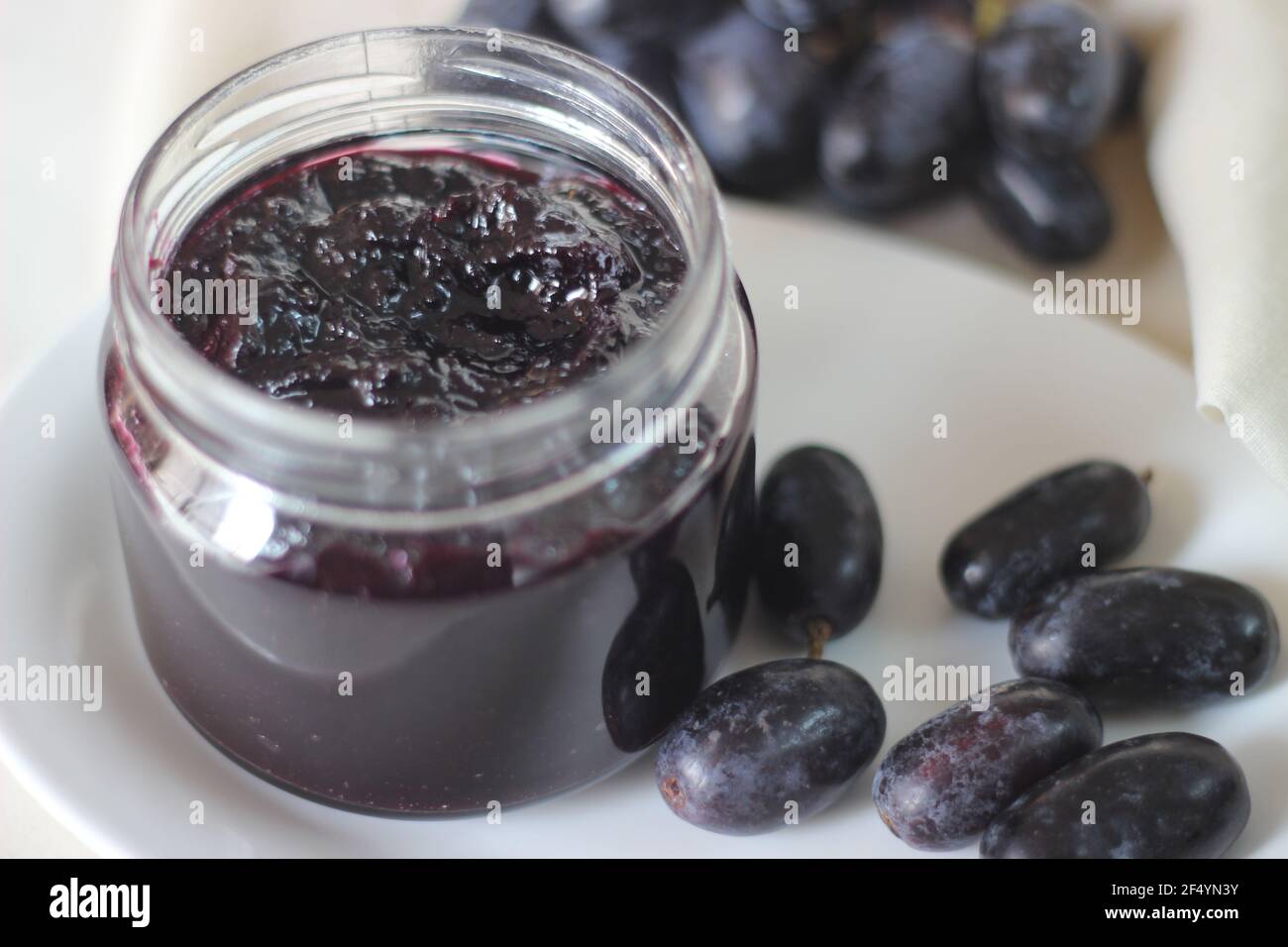 Confiture de raisin maison avec trois ingrédients, raisins noirs sans pépins, sucre et jus de lime. Prise de vue sur fond blanc Banque D'Images