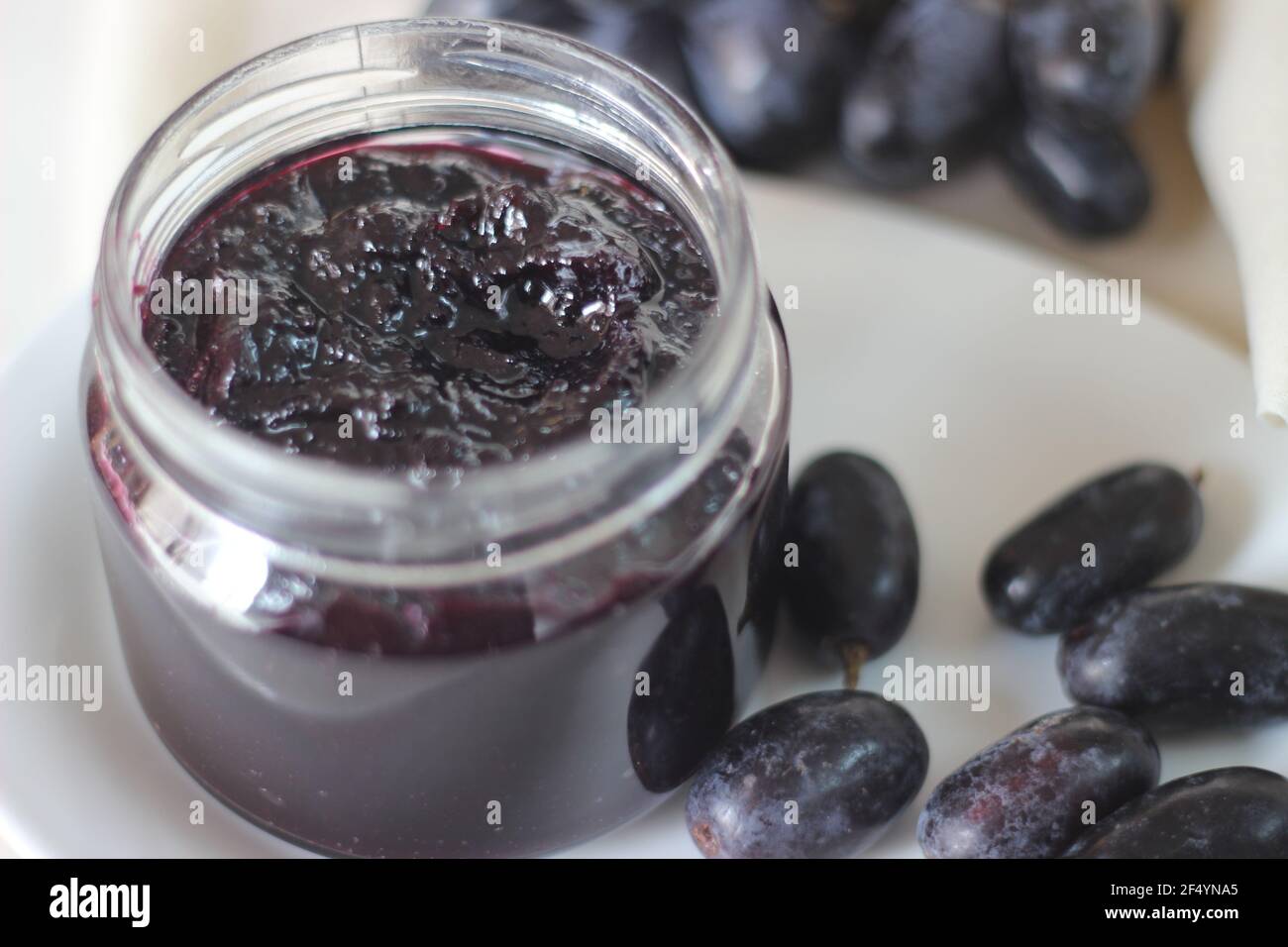 Confiture de raisin maison avec trois ingrédients, raisins noirs sans pépins, sucre et jus de lime. Prise de vue sur fond blanc Banque D'Images
