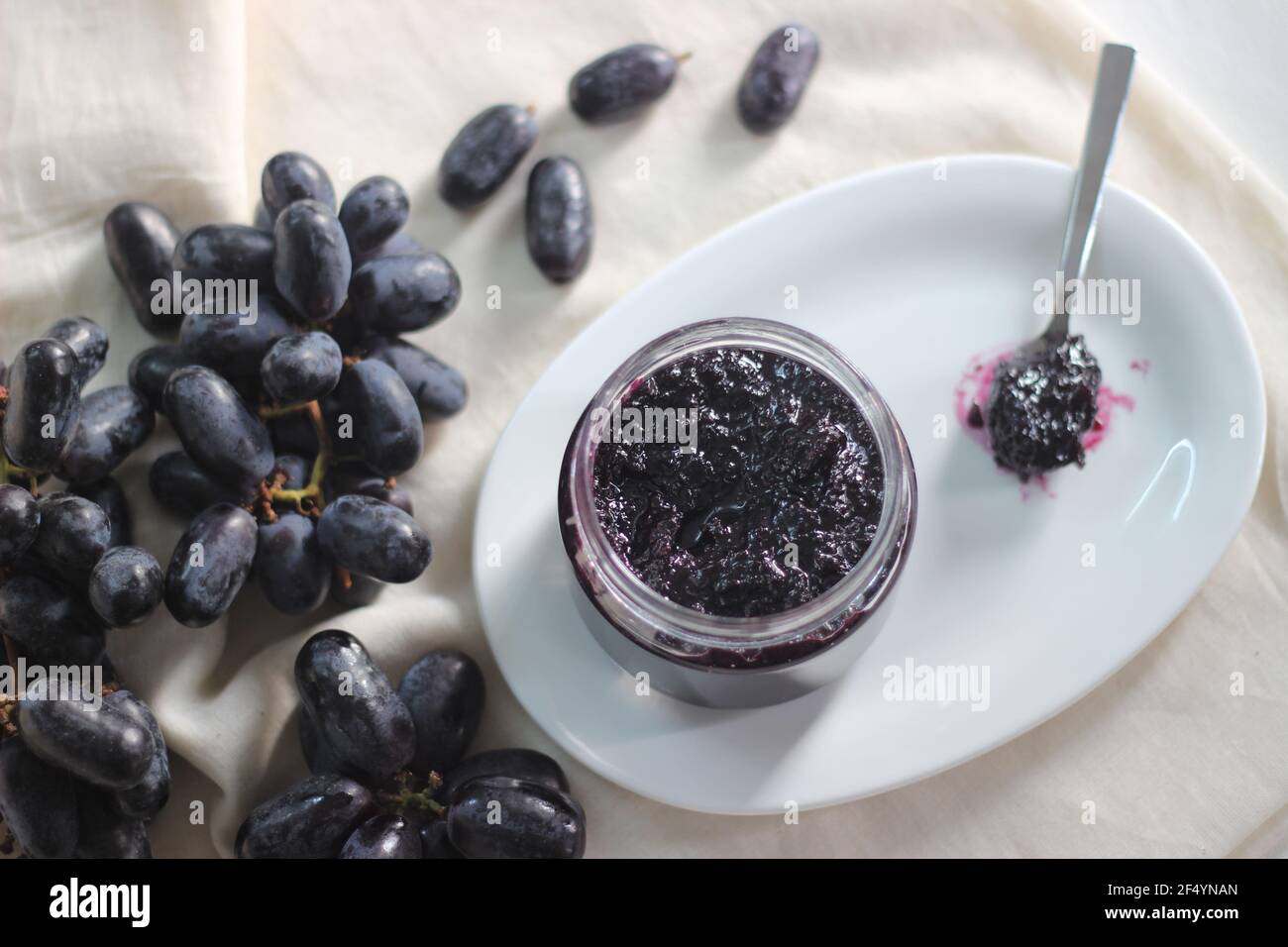 Confiture de raisin maison avec trois ingrédients, raisins noirs sans pépins, sucre et jus de lime. Prise de vue sur fond blanc Banque D'Images