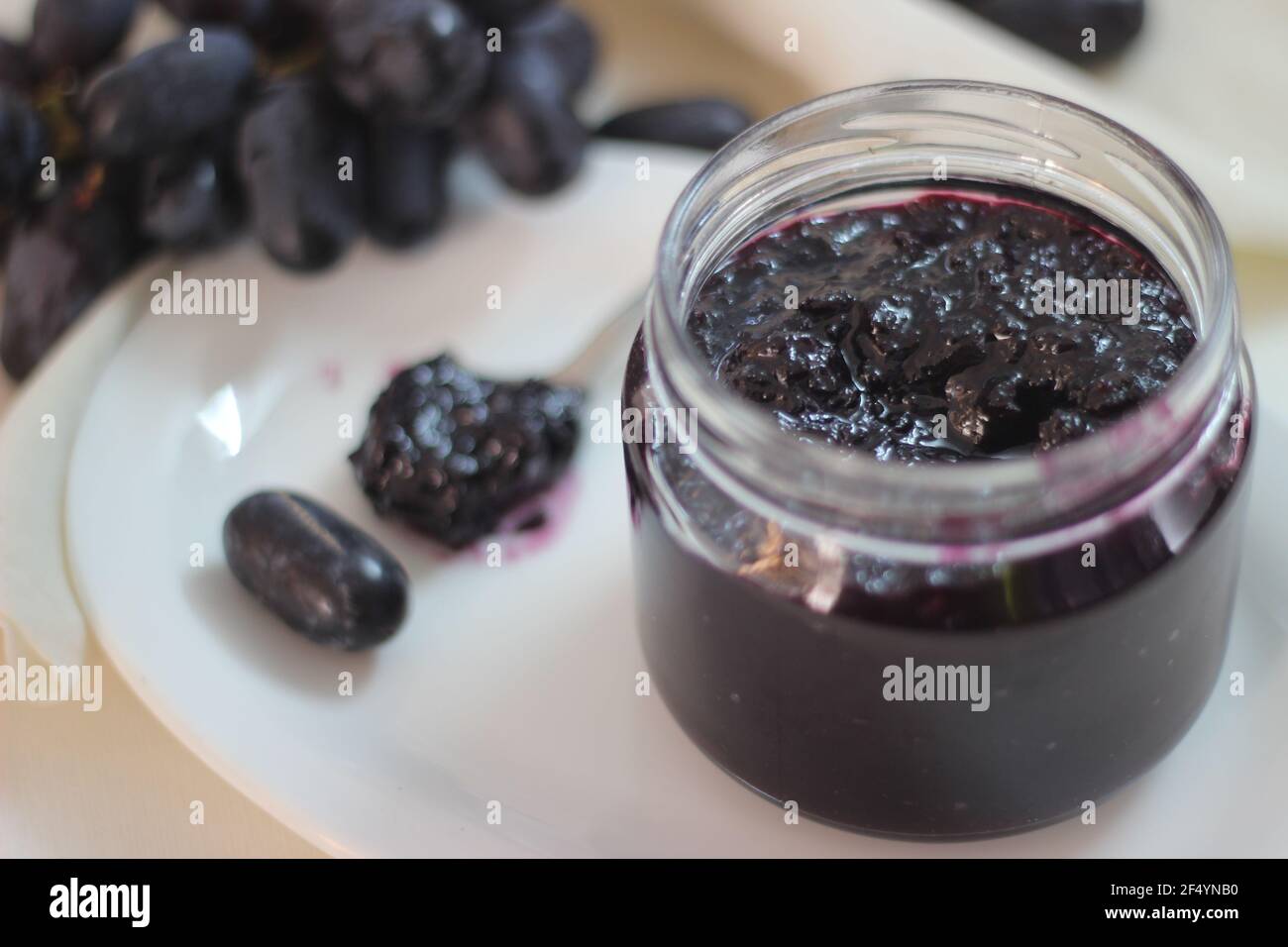 Confiture de raisin maison avec trois ingrédients, raisins noirs sans pépins, sucre et jus de lime. Prise de vue sur fond blanc Banque D'Images