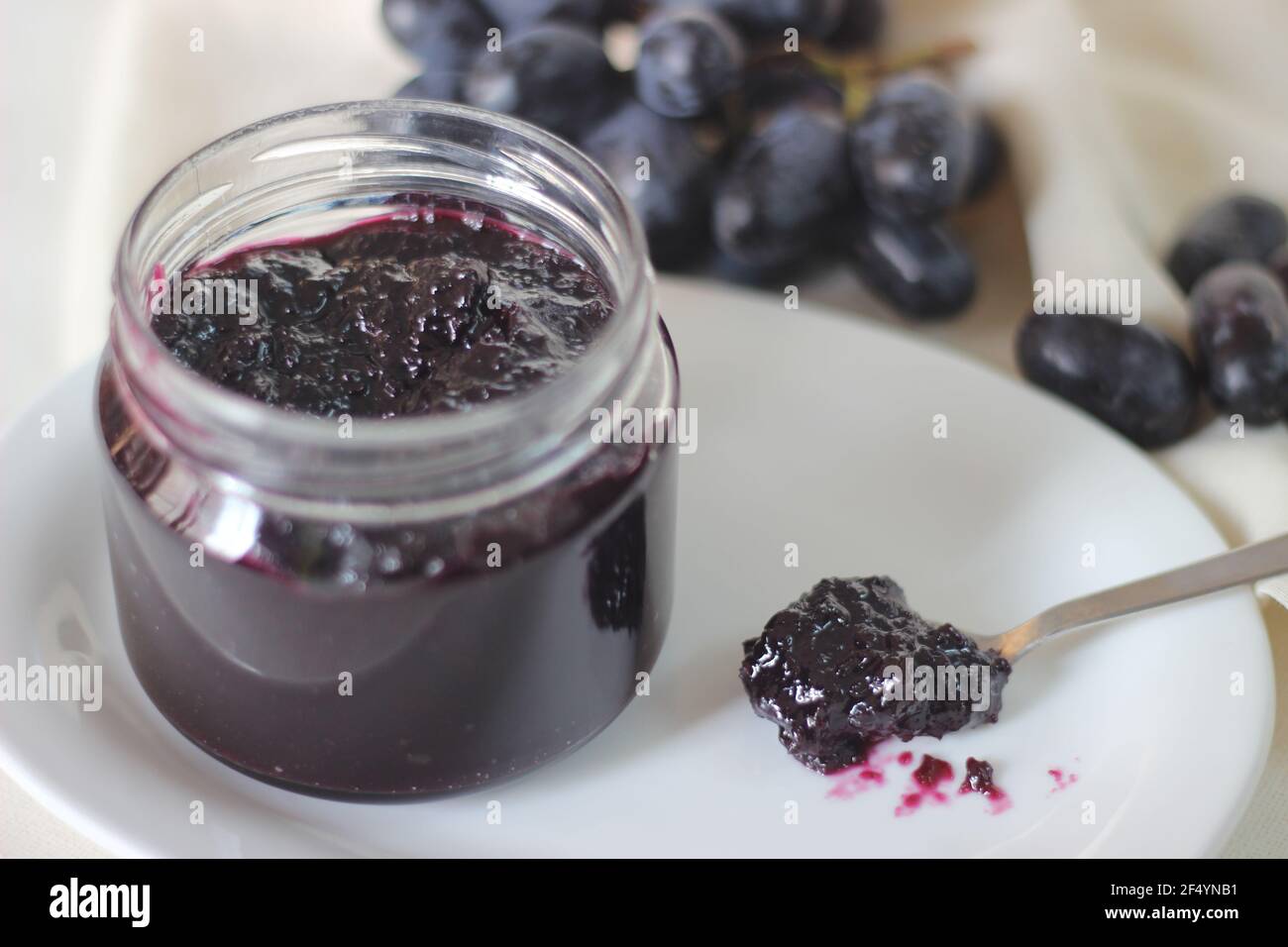 Confiture de raisin maison avec trois ingrédients, raisins noirs sans pépins, sucre et jus de lime. Prise de vue sur fond blanc Banque D'Images