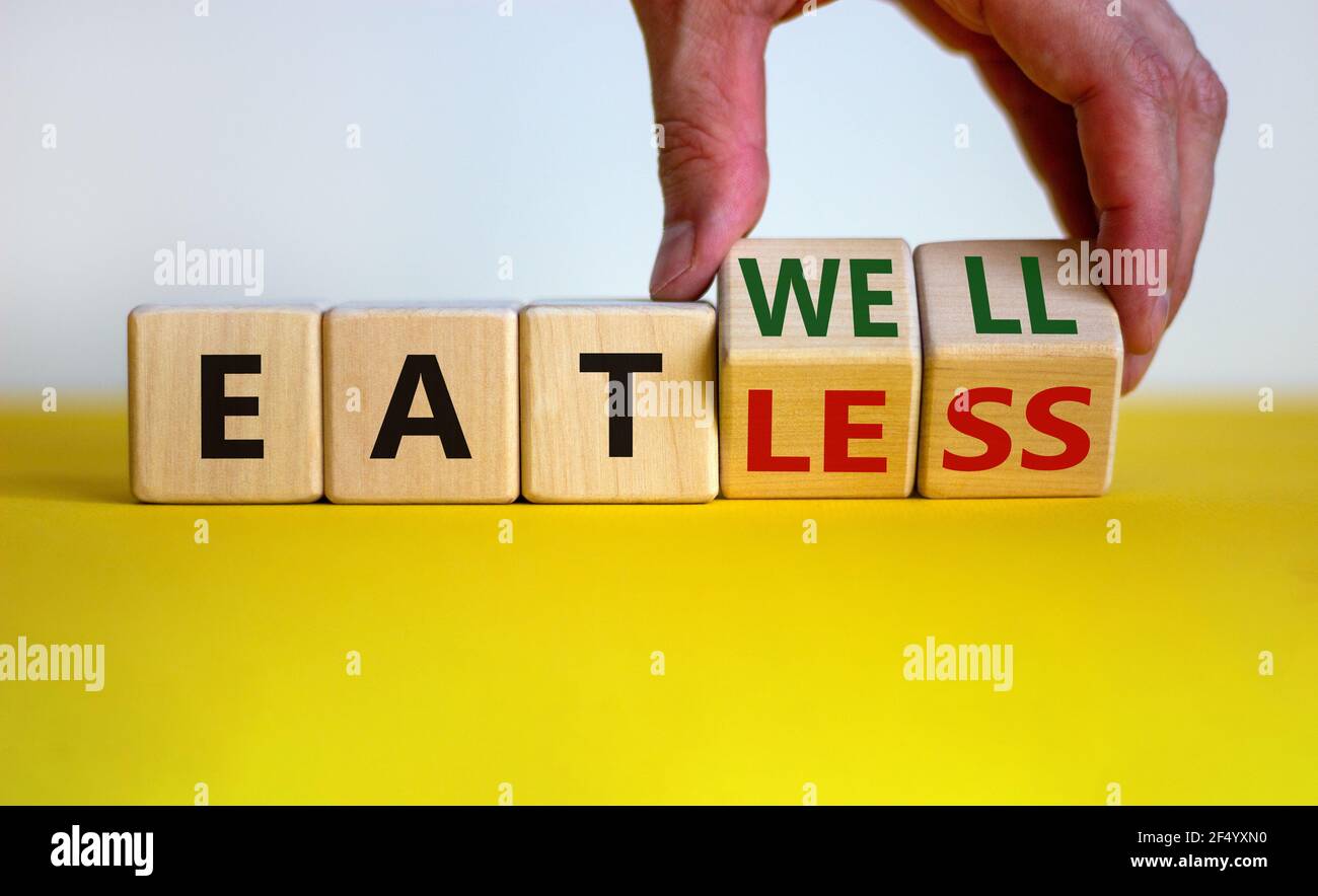 Symbole mangez bien ou mangez moins. Homme d'affaires transforme les cubes et les mots « manger moins » pour « manger bien ». Magnifique fond blanc et jaune. Affaires, manger Banque D'Images