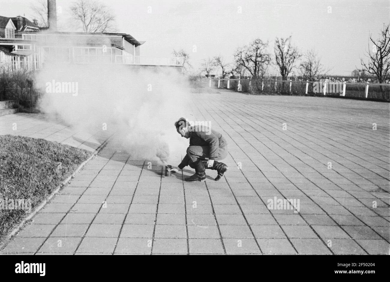Deuxième Guerre mondiale. Homme pendant un exercice avec une cartouche de gaz de combustion (probablement aux pays-Bas) Banque D'Images