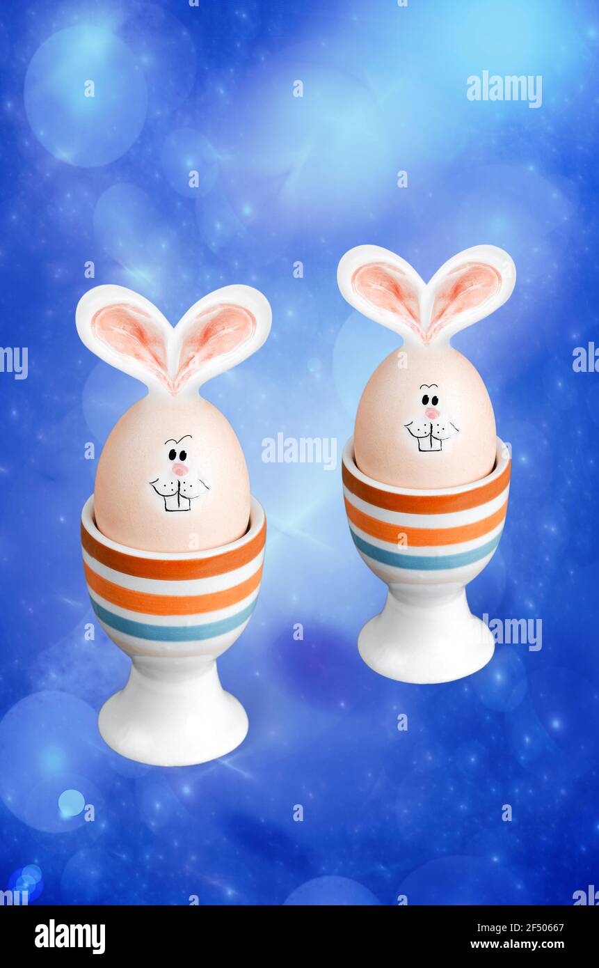 Oeufs de Pâques avec oreilles de lapin et muzzles sur fond bleu fractal. Le concept de Pâques Banque D'Images