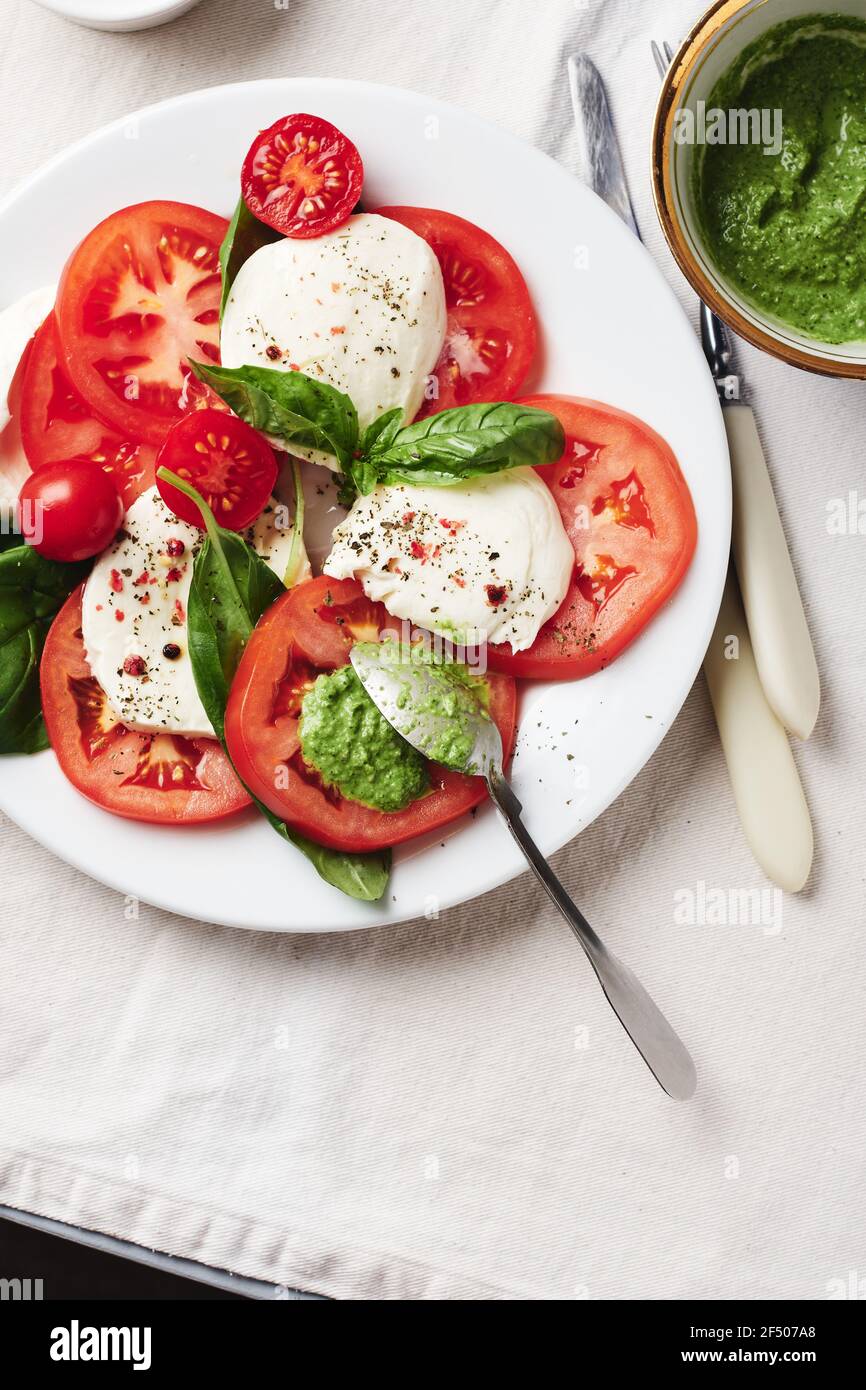 Salade Caprese. Tomates, fromage mozzarella, feuilles de basilic et sauce pesto. Banque D'Images