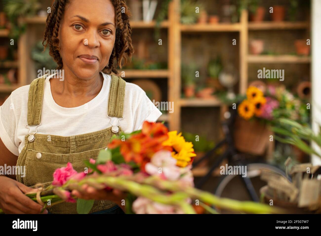 Portrait femelle fleuriste organisant des fleurs dans la boutique Banque D'Images