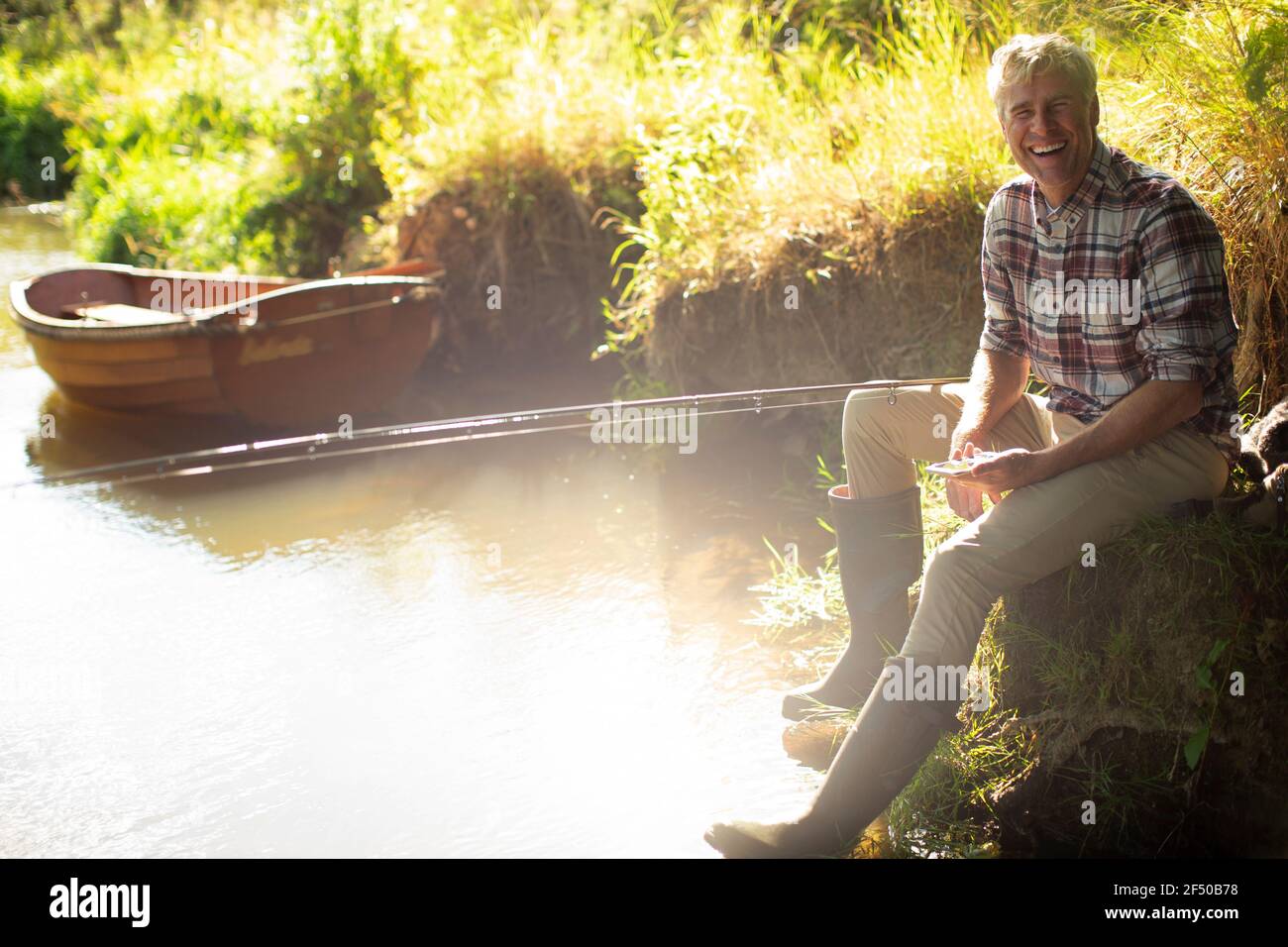 Portrait Happy man pêche à la mouche sur la rive ensoleillée Banque D'Images