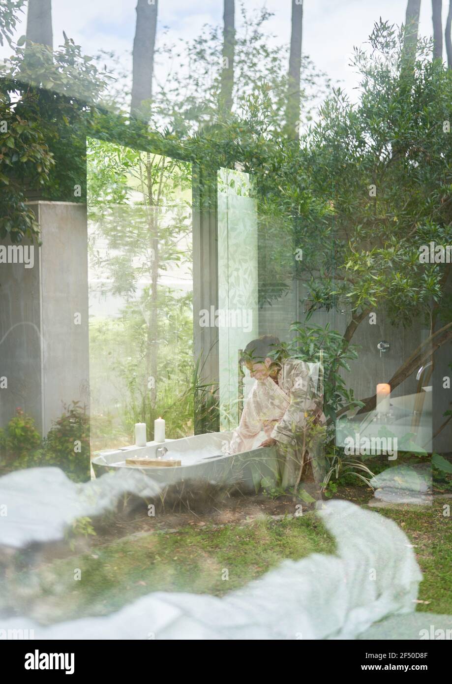 Femme préparant une baignoire dans une salle de bains moderne de luxe Banque D'Images