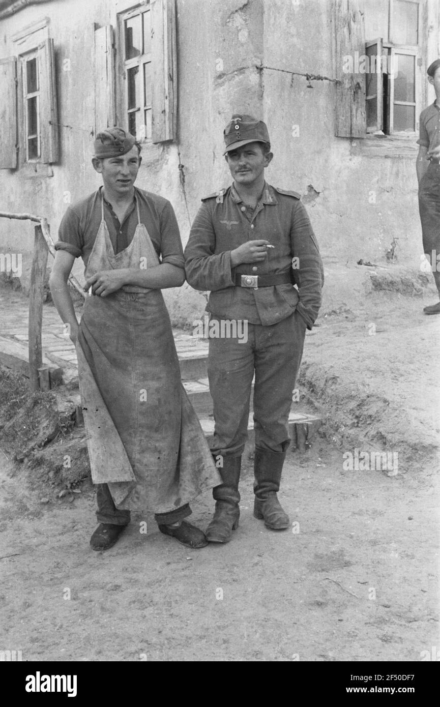 Deuxième Guerre mondiale. Photos avant. Deux hommes fument (peut-être un local avec une casquette militaire allemande, droit un Wehrmachiger) Banque D'Images