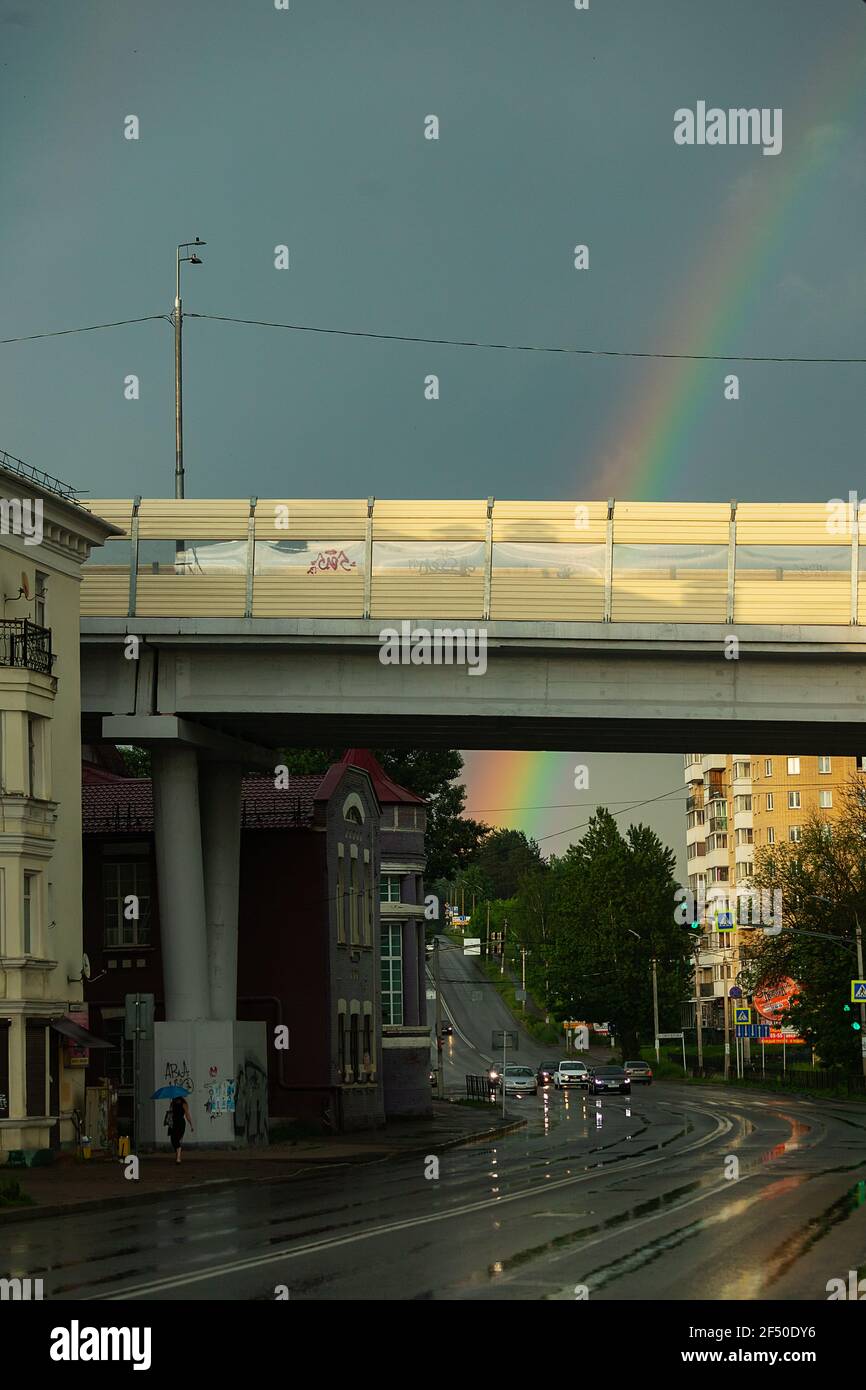 arc-en-ciel au-dessus de la ville après la pluie. une vieille locomotive à vapeur se trouve à la gare Banque D'Images