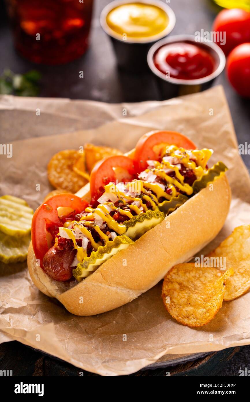 Hot dog avec tomates, moutarde et cornichons Banque D'Images