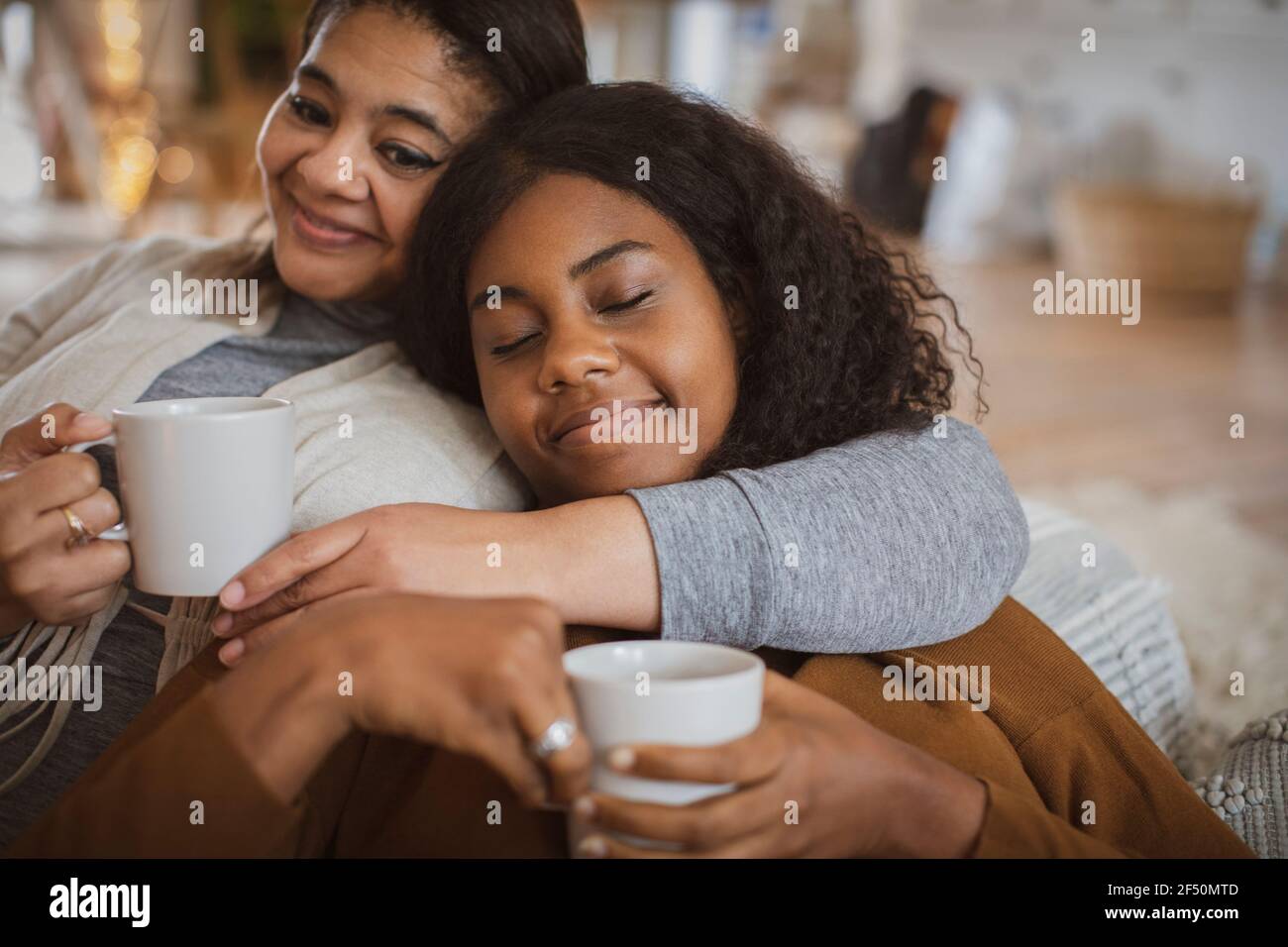 Une mère et une fille affectueuses qui se câline avec du thé Banque D'Images