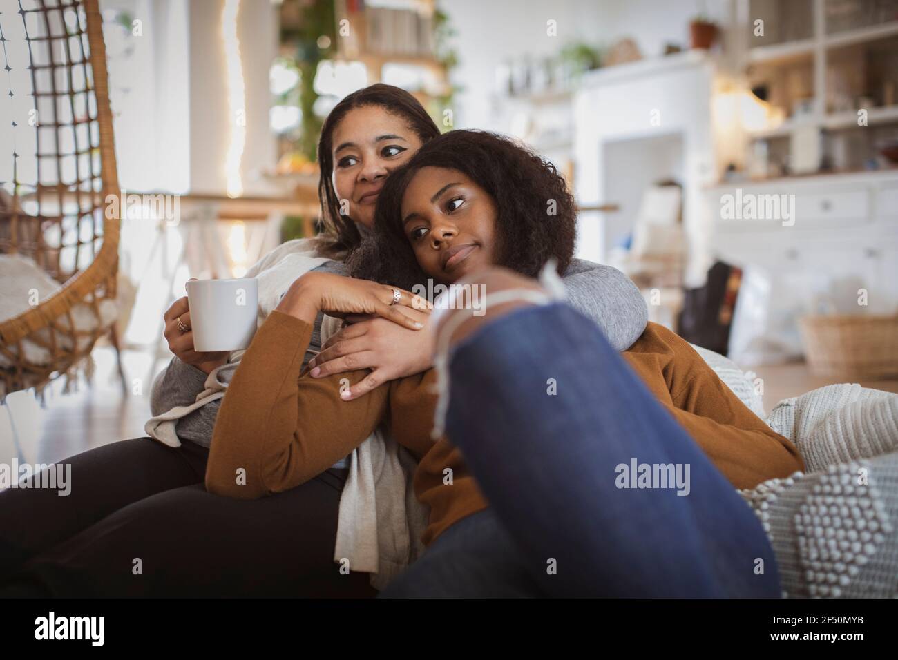 Une mère et une fille affectueuses se câliner sur le canapé Banque D'Images