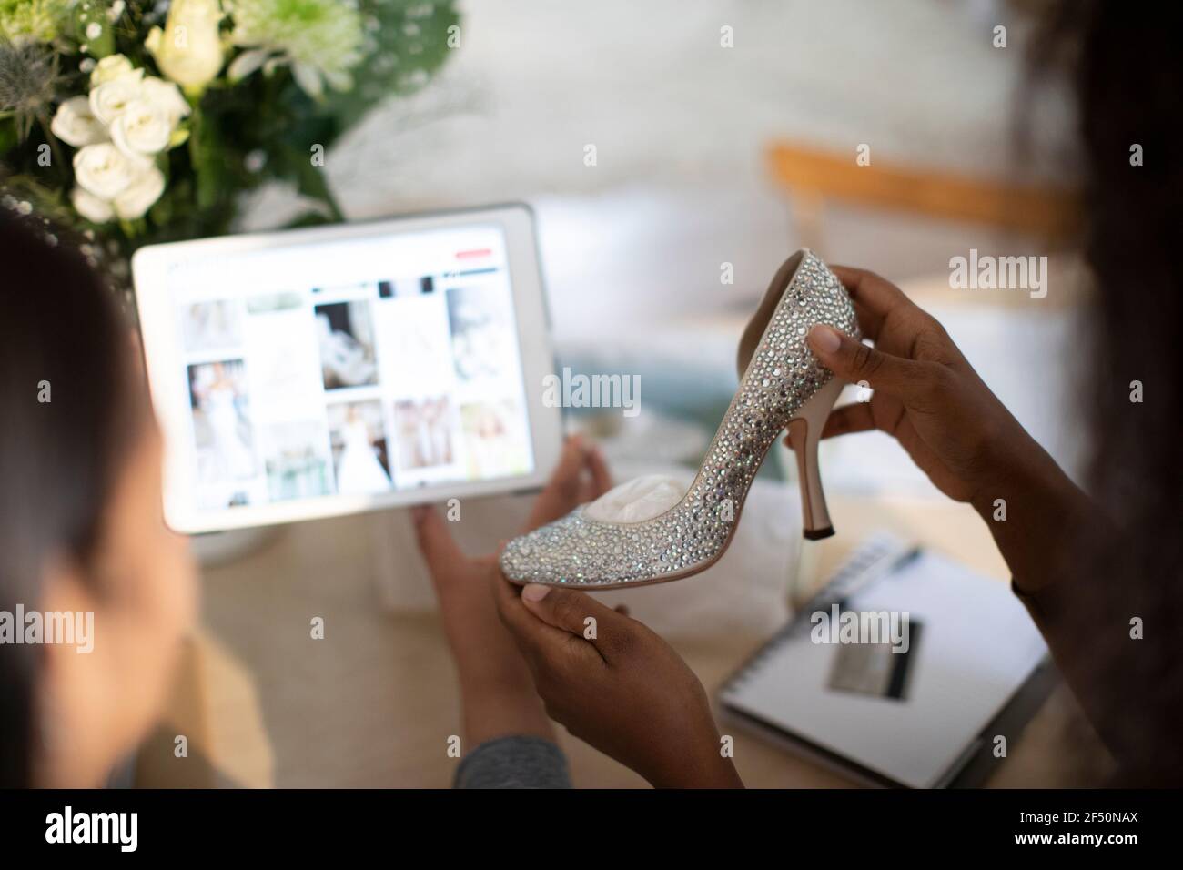 Des femmes avec des chaussures de mariage pour acheter des idées sur une tablette numérique Banque D'Images