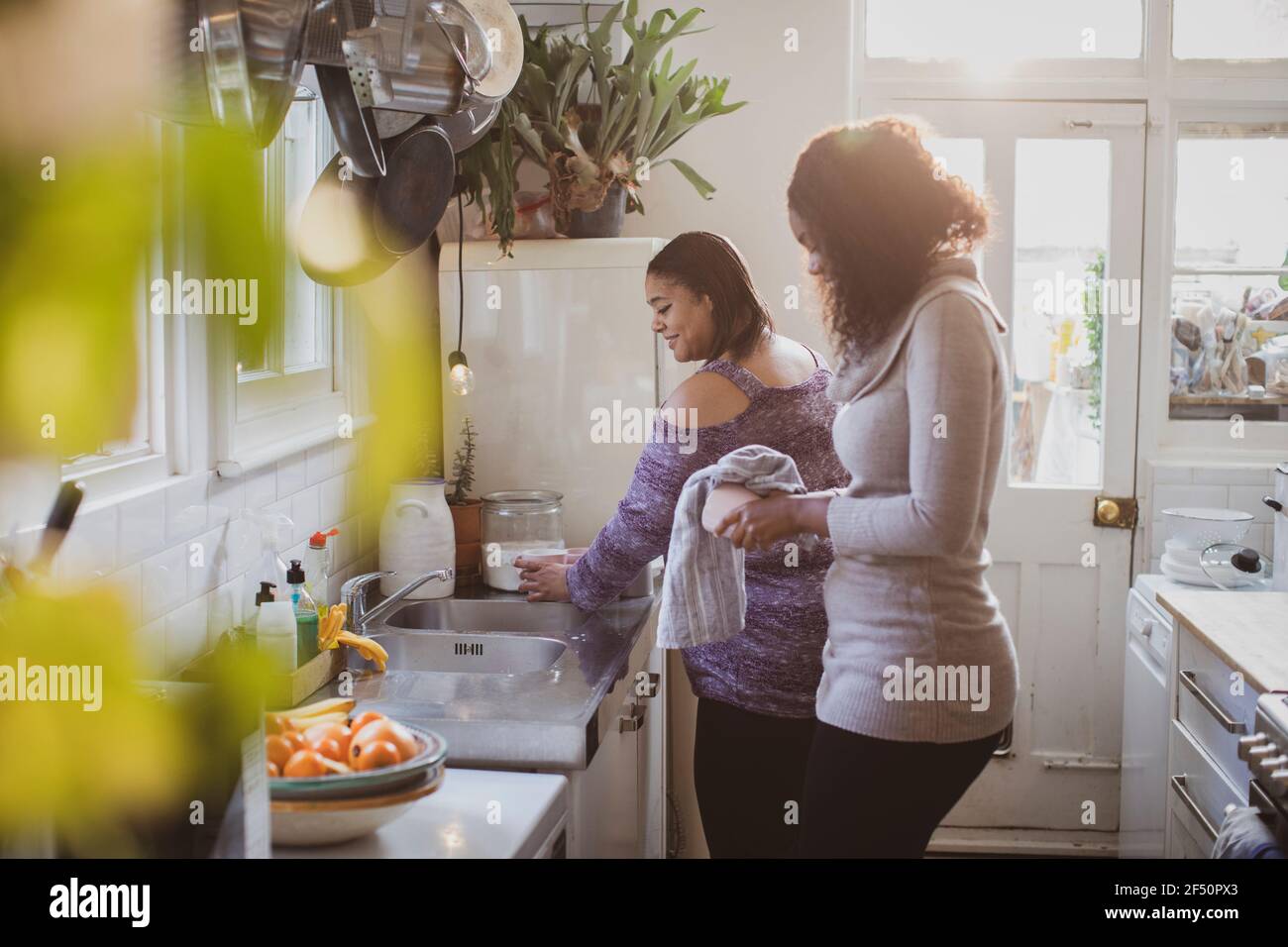Mère et fille à faire la vaisselle à l'évier de cuisine Banque D'Images