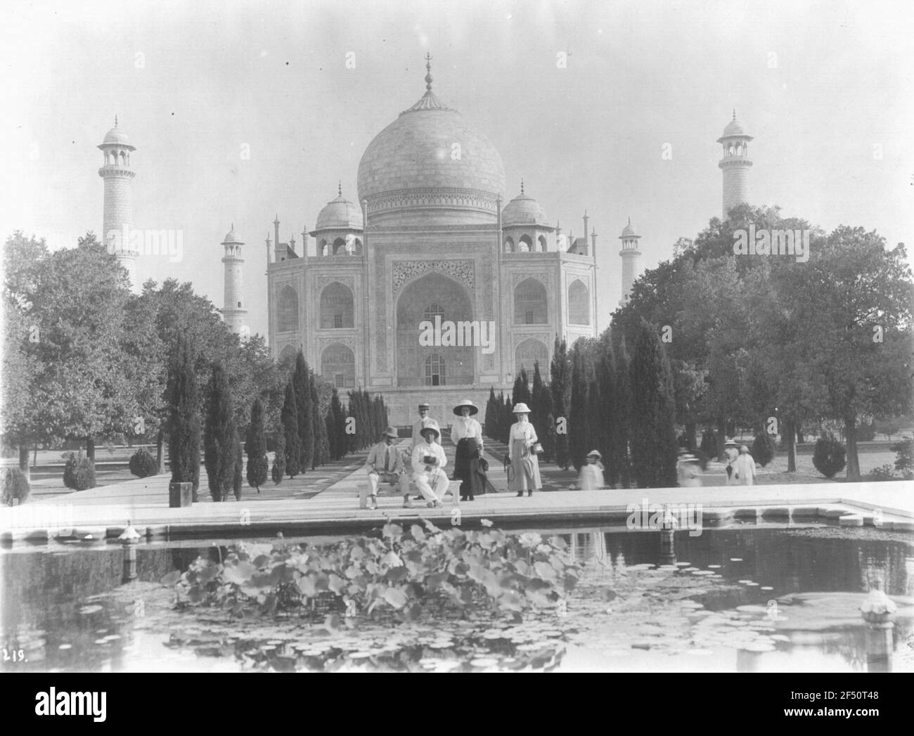 Touristes posant sur le bassin d'eau avant le Taj Mahal Banque D'Images