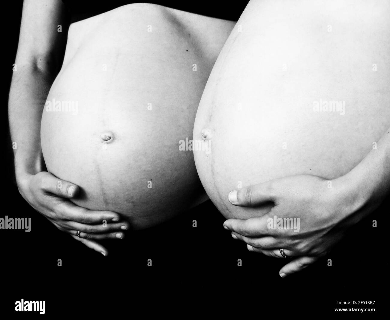 Réflexion du ventre enceinte dans le miroir en b / n Banque D'Images