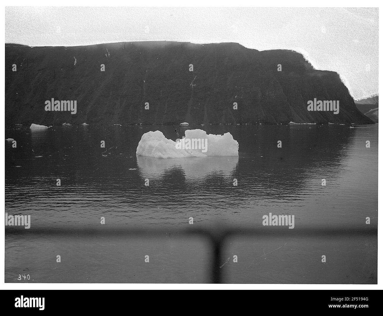 Spitzbergen. Iceberg flottant sur la côte rocheuse et paysage de baie au-dessus de l'enroulement du paquebot de haute mer 'Victoria Luise Banque D'Images