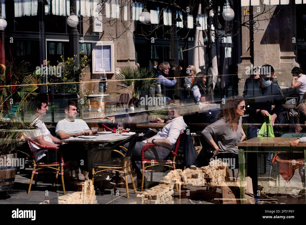 Les gens qui profitent du soleil et des boissons sur une terrasse, Barcelone, Espagne. Banque D'Images