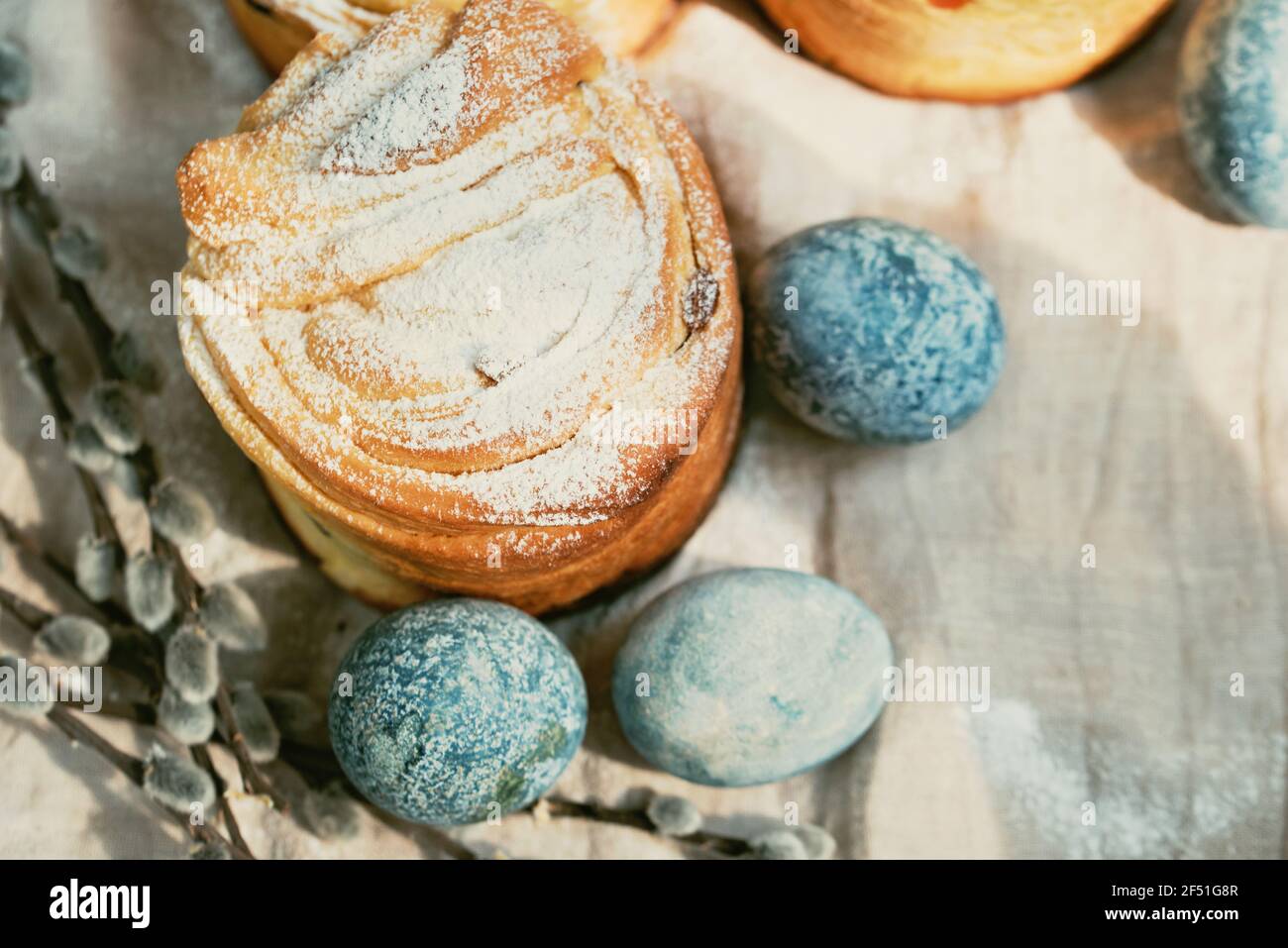 Gâteau traditionnel gâteau de Pâques kraffin aux raisins secs sur fond de bois foncé. Gâteau maison Cruffin aux fruits confits. Œufs naturellement peints avec Banque D'Images