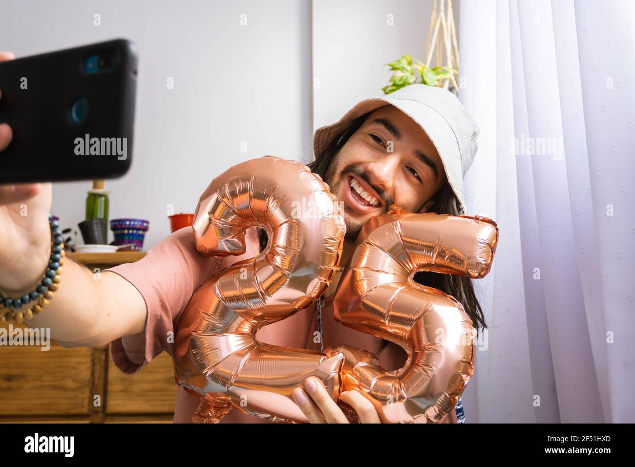 Jeune homme attirant d'asie latine prenant un selfie seul, tenant une montgolfière métallique, célébrant son 25e anniversaire. Ballon métallique avec numéro Banque D'Images